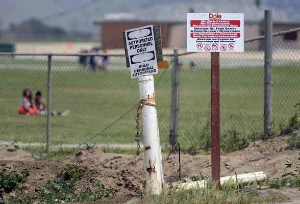 A sign in an agriculture field adjacent to Gavilan View Middle School in Salinas warns of nearby pesticide application in May 2014. (David Royal - Monterey Herald) 