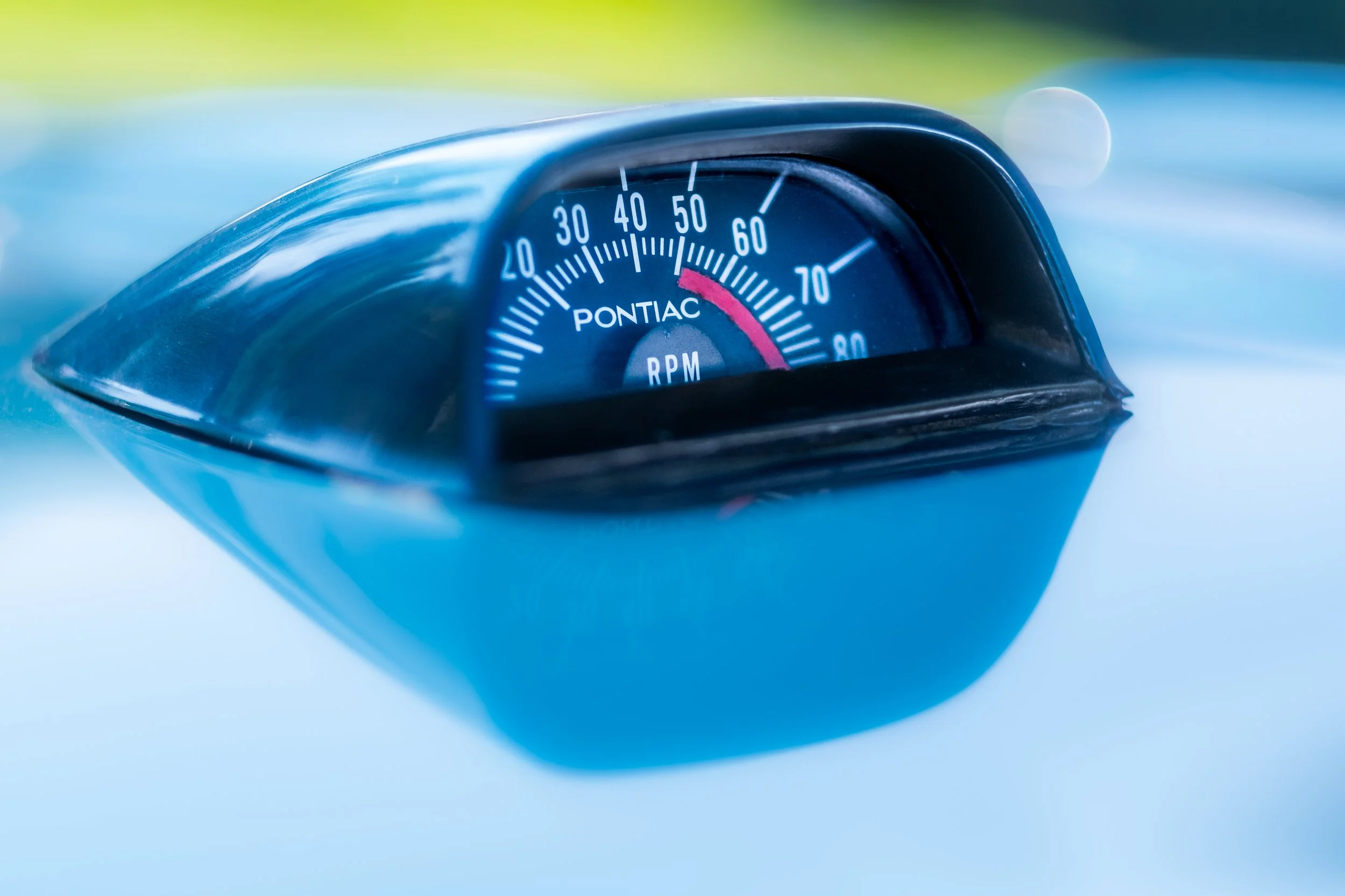 Close-up of a Pontiac car tachometer gauge showing around 55 RPM