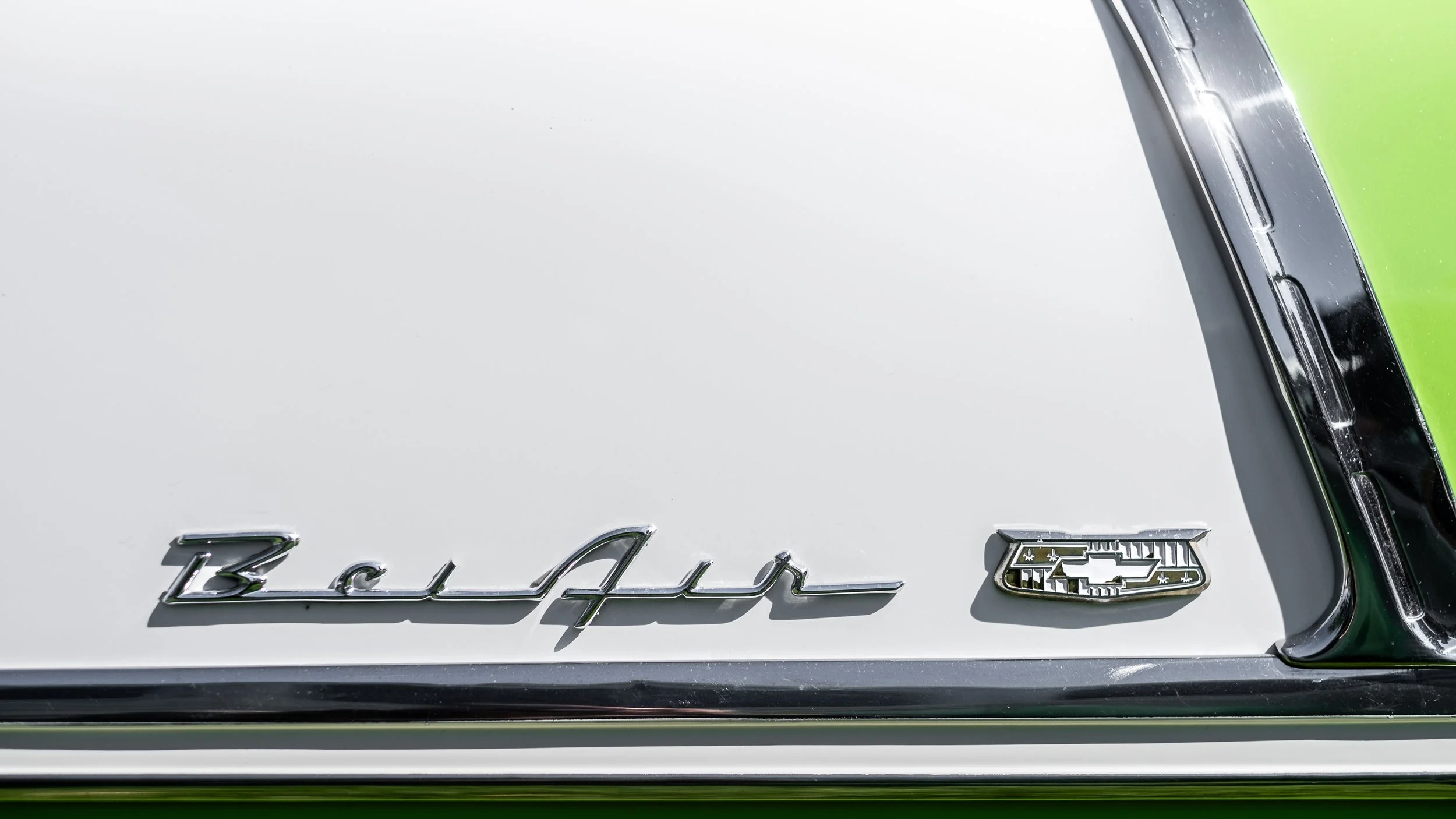 Close-up of the rear badge on a white Chevrolet Bel Air car, showing the model name and logo.