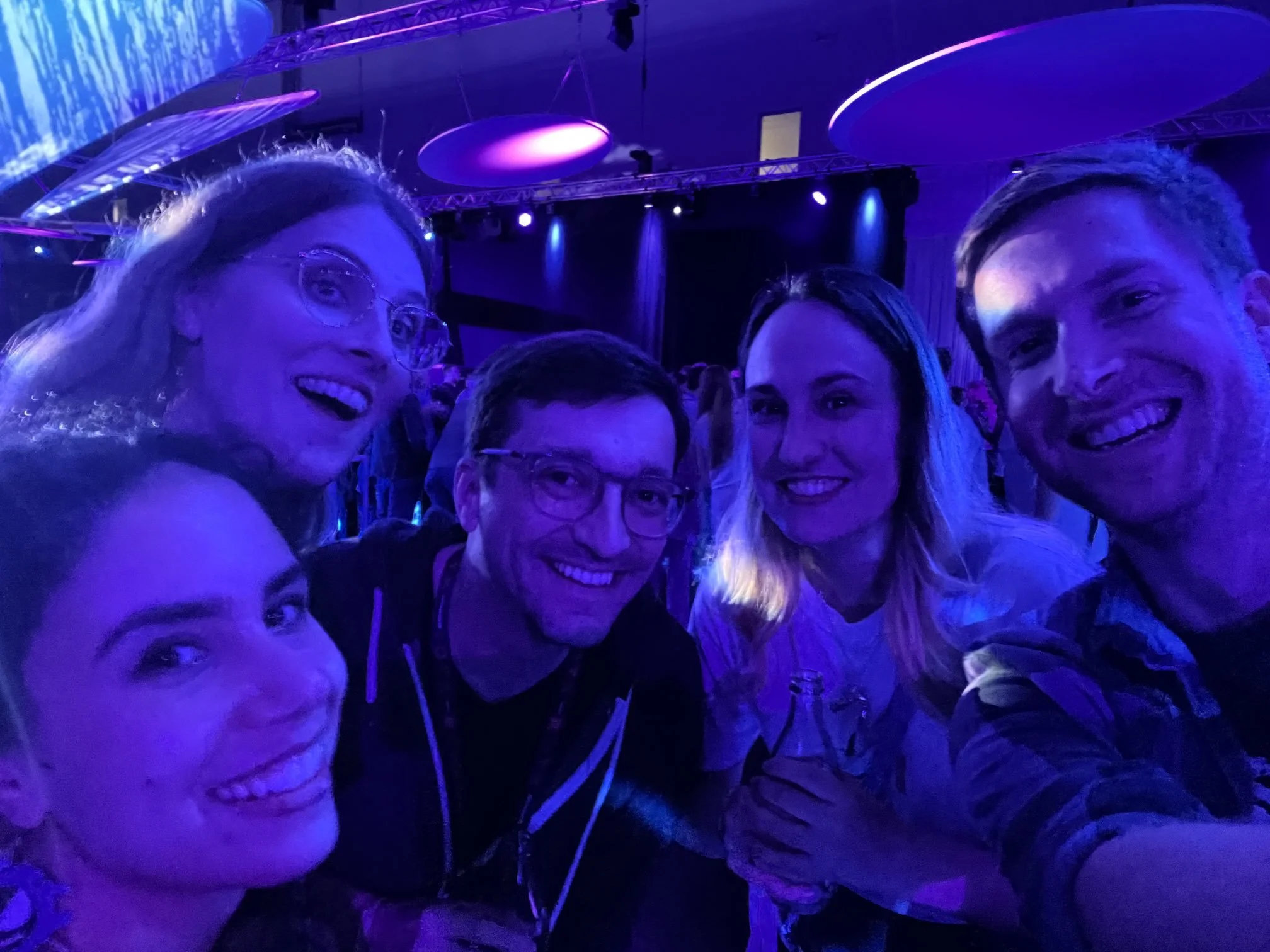 Sofia Hariz, Isla Hinck, Kyle Bosman, Anne Wernicke and Michael Huber smiling together backstage in a dimly lit room after Opening Night Live in Germany in 2024