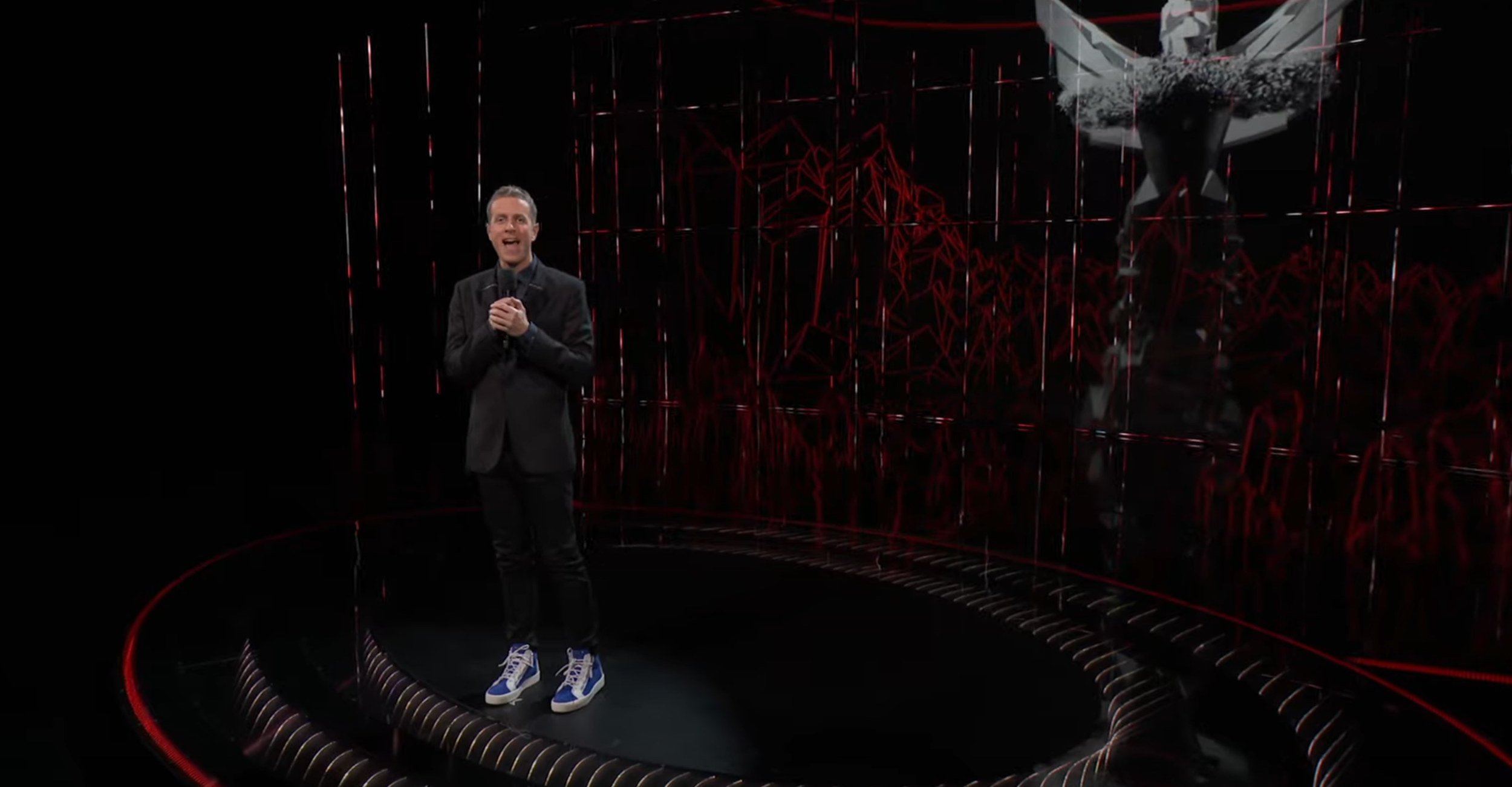 Geoff Keighely wearing a dark suit and blue sneakers at the 2020 Game Awards