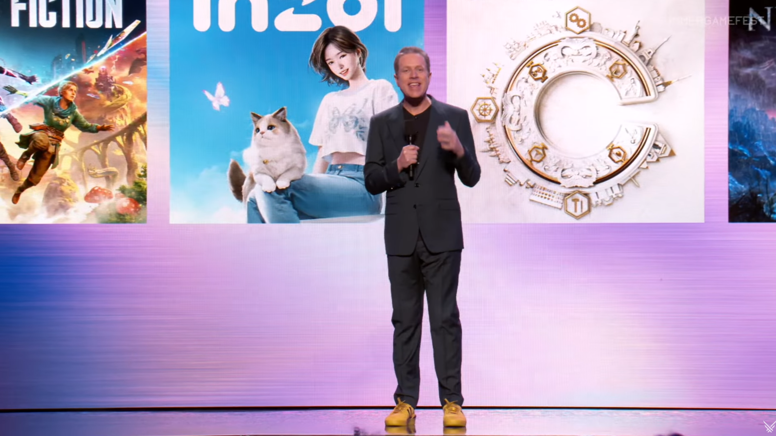 Geoff Keighley wearing a dark suit and bright yellow sneakers while talking about some of the year's new releases on-stage at Summer Game Fest 2025