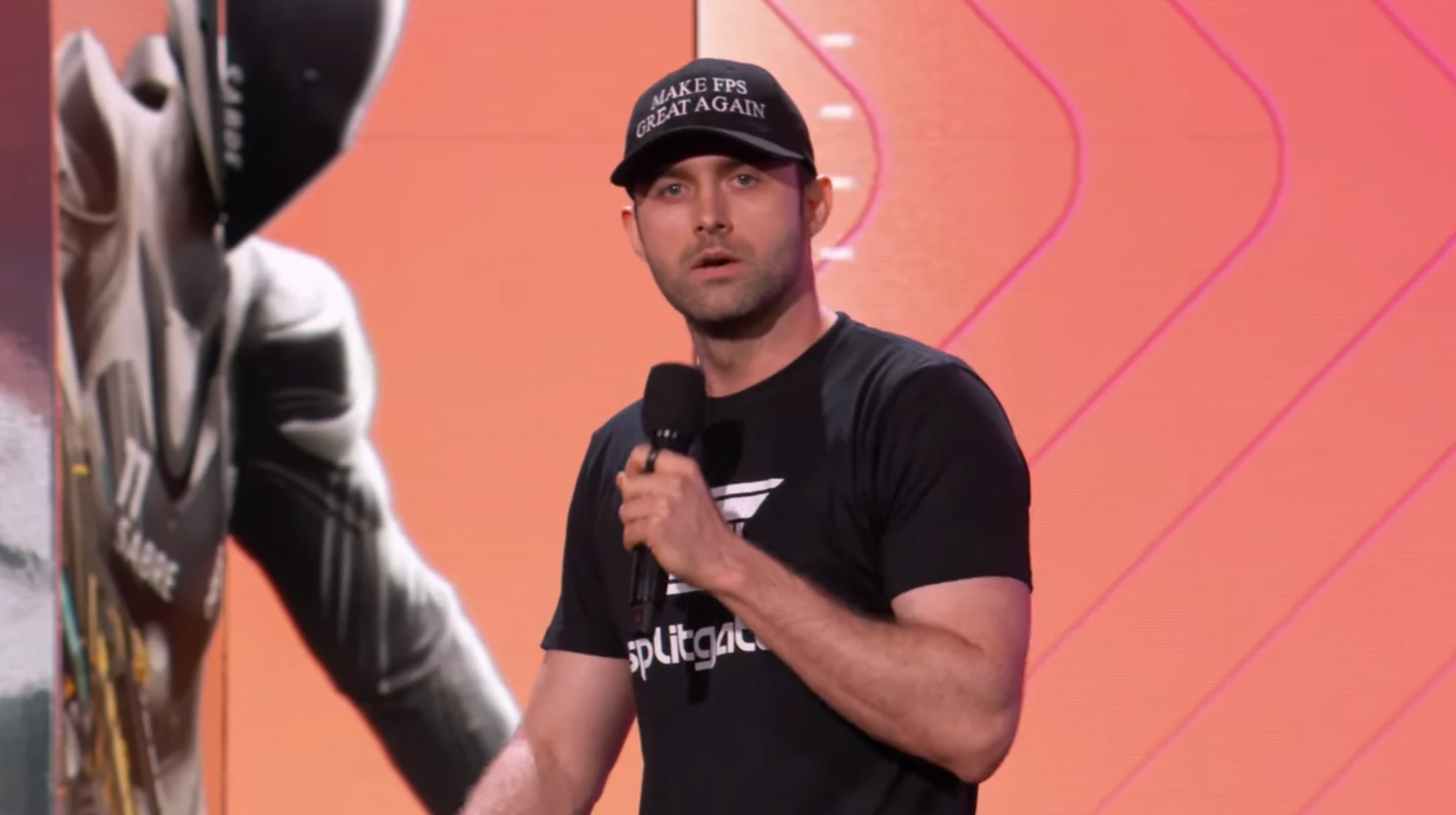 Splitgate 2 CEO Ian Proulx on-stage at the 2025 Summer Game Fest wearing a black hat that says "Make FPS Great Again" in a similar font to the "Make America Great Again" hats,.