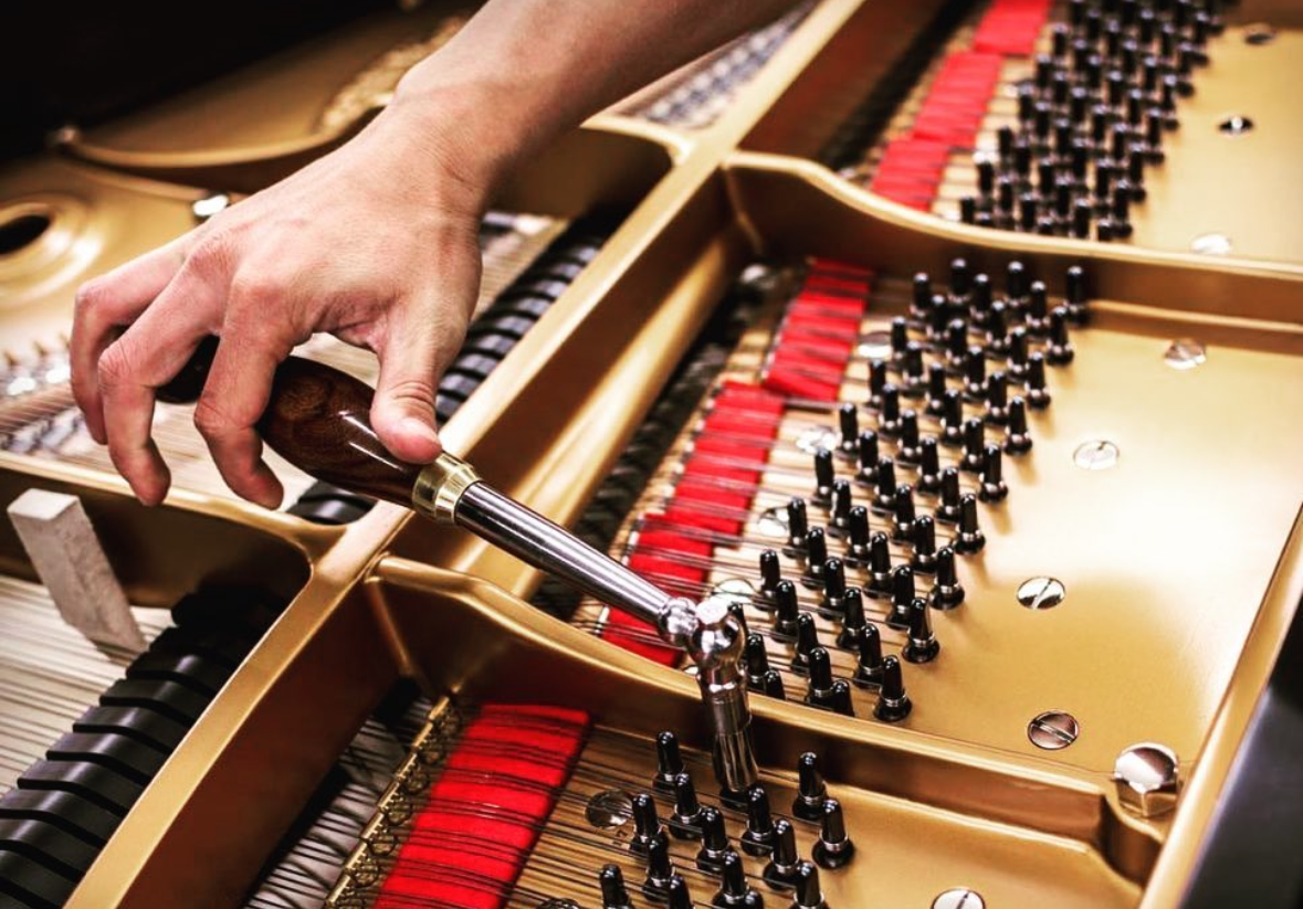 Image of someone tuning a grand piano