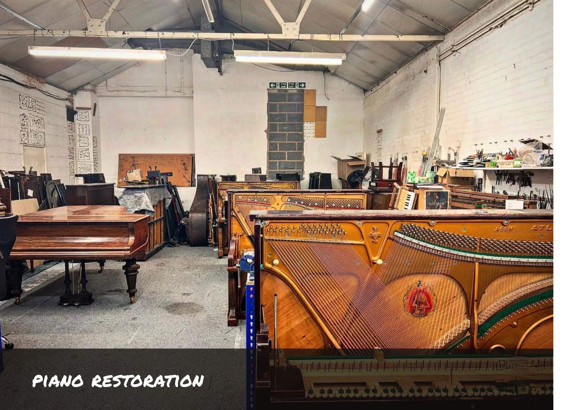 Piano workshop with a few uprights and a grand piano set up ready to be worked on