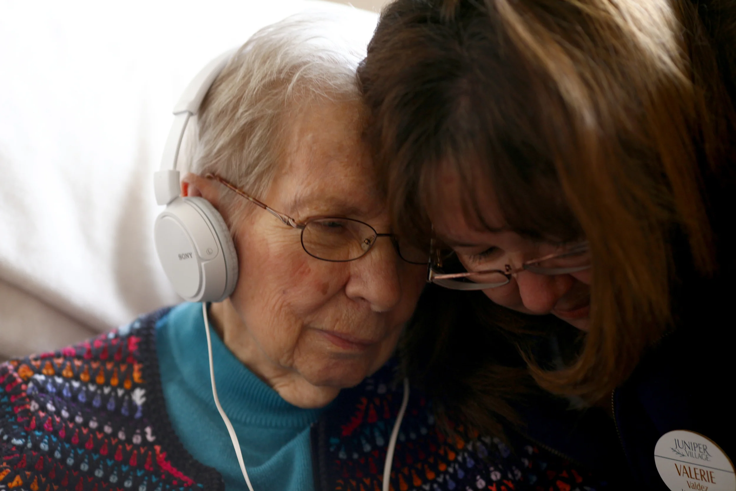Aurora, CO-Dorothy Richerson, left, a resident of Juniper Village in Aurora, listens to "It Had to be You" with Executive Director Valerie Valdez Jan. 29, 2015. The long-term memory care facility is introducing a new Music and Memory program that provides residents an opportunity to listen to music from their early years on iPods and headphones that have been donated to the facility.
