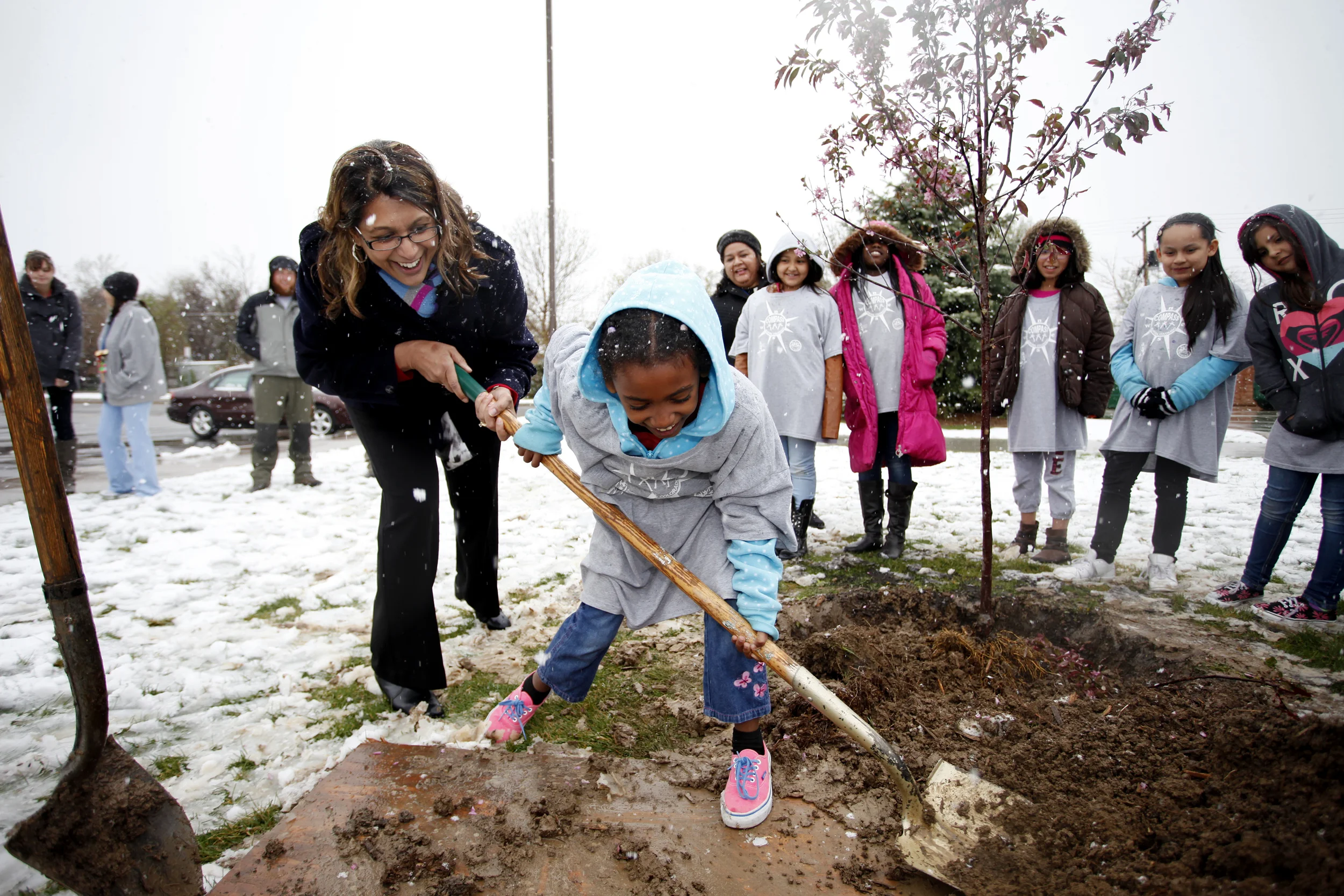 Aurora, CO-Vaughn Elementary School Principal Sangita Patel lends a hand to second grader Galgala Bati while scooping a hefty pile of dirt to place on a Royal Raindrops Crabapple tree April 16, 2015. COMPASS students who participate in the after school program at Vaughn Elementary won a poetry contest and won the privilege of planting the official Arbor Day Tree.