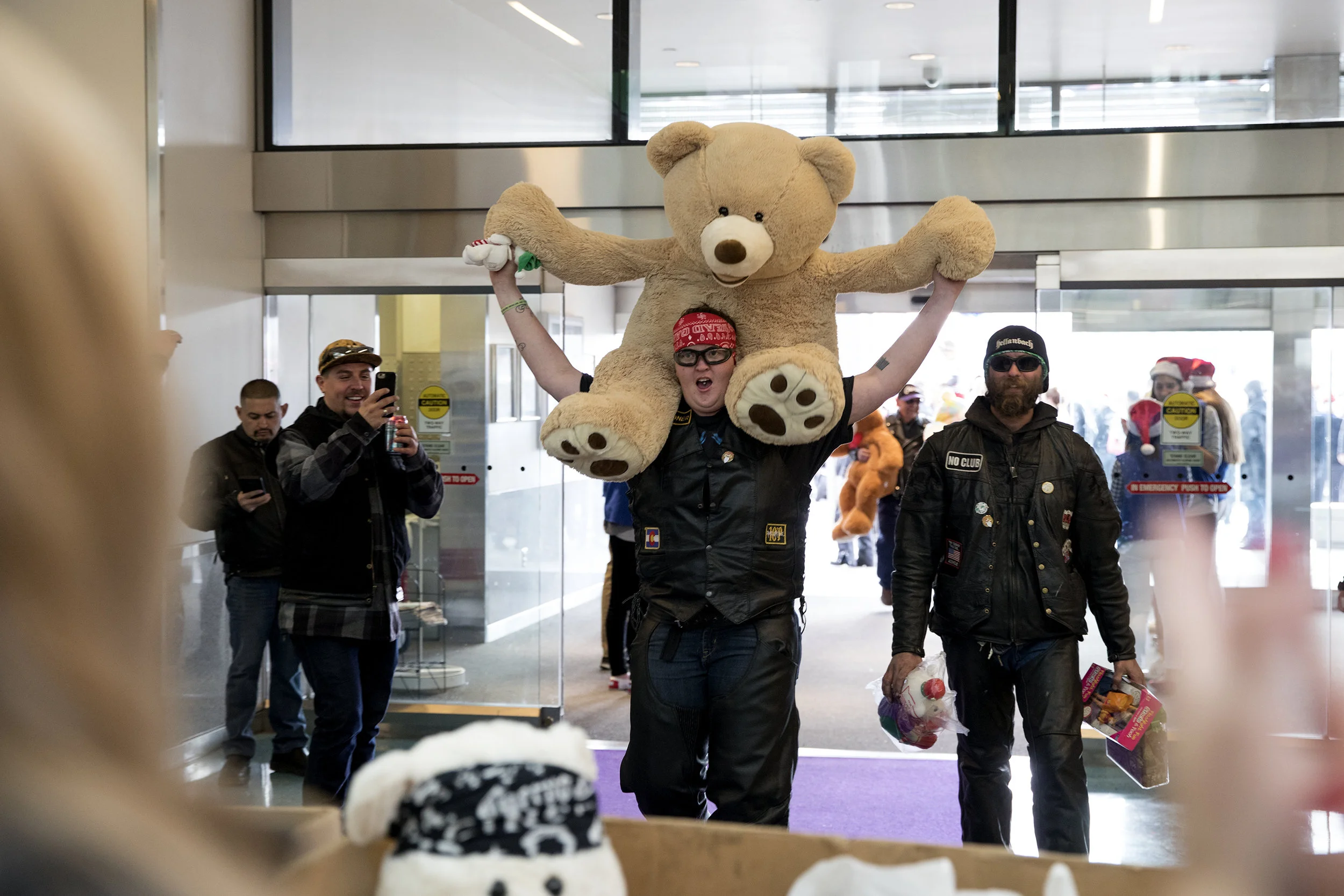 Alissa Davis enters the atrium of the children's hospital with a giant teddy bear to donate Dec. 3 during the 32nd Annual Children's Hospital Colorado Toy Run. This is Alissa's second year participating in the event, where thousands of motorcyclists meet at Aurora Sports Park and travel in a convoy to the hospital to deliver their toy donations for the patients to receive during the holidays.