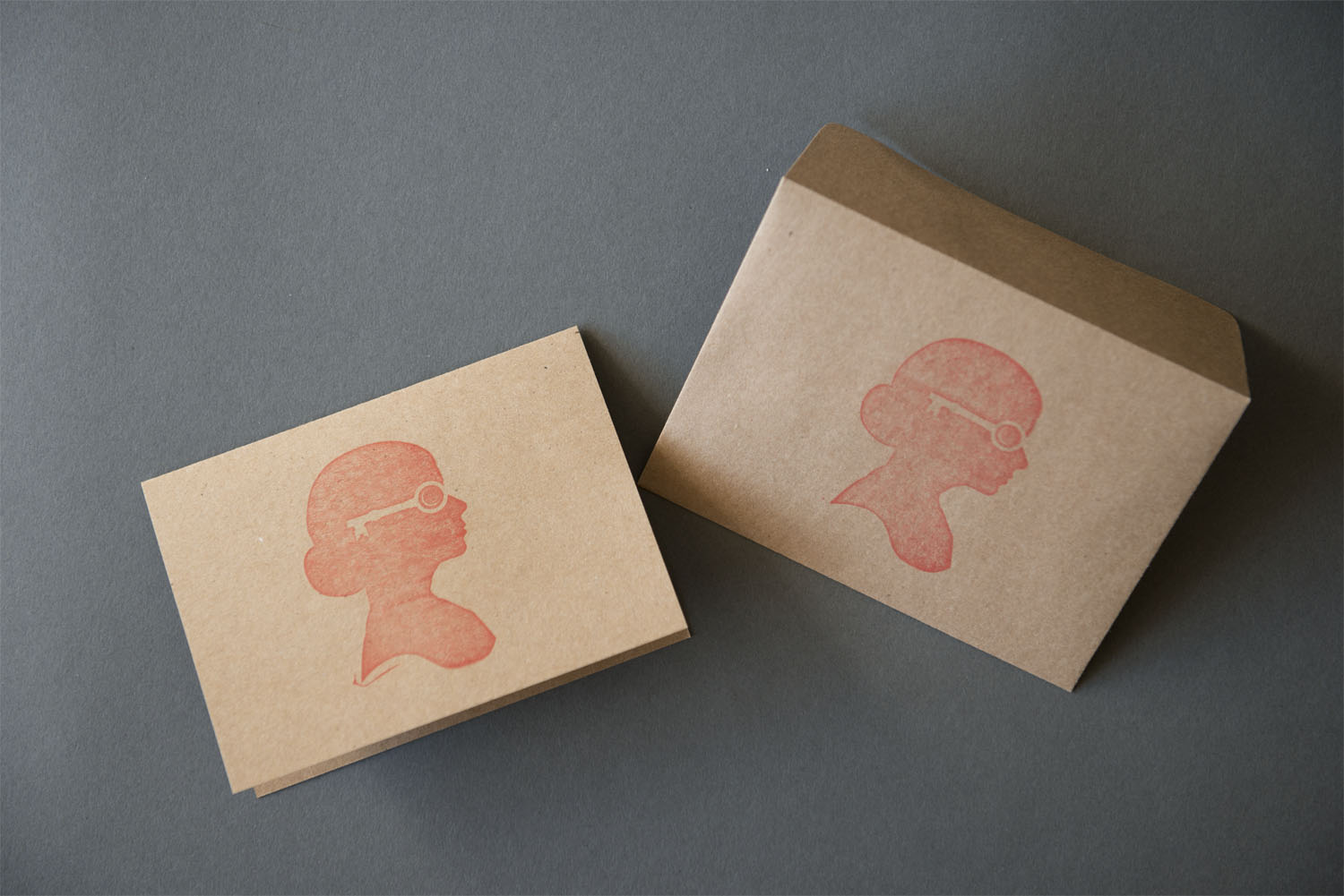 We love the look and natural texture of these note cards, but the real gem here is the logo. Designed by Heather herself, it is a perfect reflection of her work; vintage-inspired, feminine, and classic. The silhouette is easily readable and the graphic quality of the cutout works in any size or color scheme. The key motif is cleverly repeated as a physical object that ties the cards together.