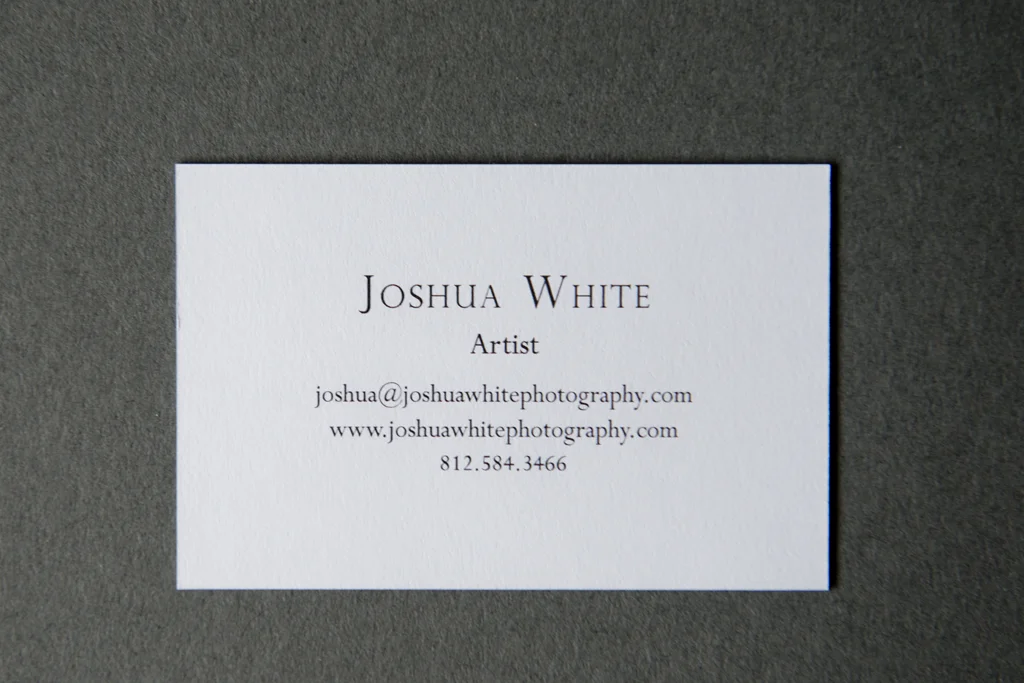 Joshua White’s business cards are minimal and elegant, just like his photographs. Printed with Moo’s luxe line, the multi-ply white textured paper contains a black core that makes them not only sturdy, but also ties in with the text color. His logo, a simple serifed ‘W’, is prominently displayed on one side with just the essential contact information on the other. The small-serif font is classic rather than modern, fitting with both the rich paper and his imagery. Joshua White’s limited edition print was released this month as part of Don’t Take Pictures’ print sale .