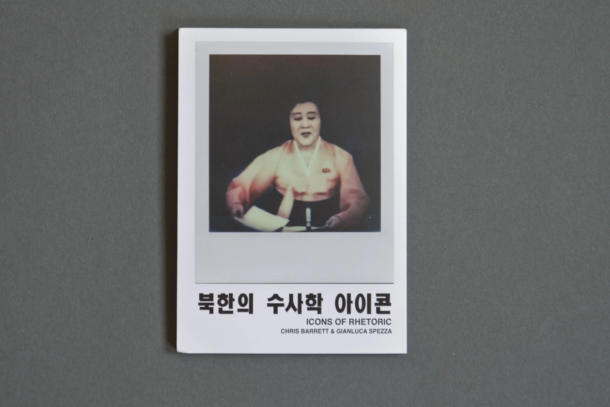 Polaroid photographs often struggle to be reproduced in a manner that does justice to their nature as a unique physical object. This accordion style booklet is an excellent representation of the work. The size is similar to the original Polaroids, but leaves room for text. The title written in Korean characters provides a glimpse into the content of the work, which focuses on North Korea’s media.