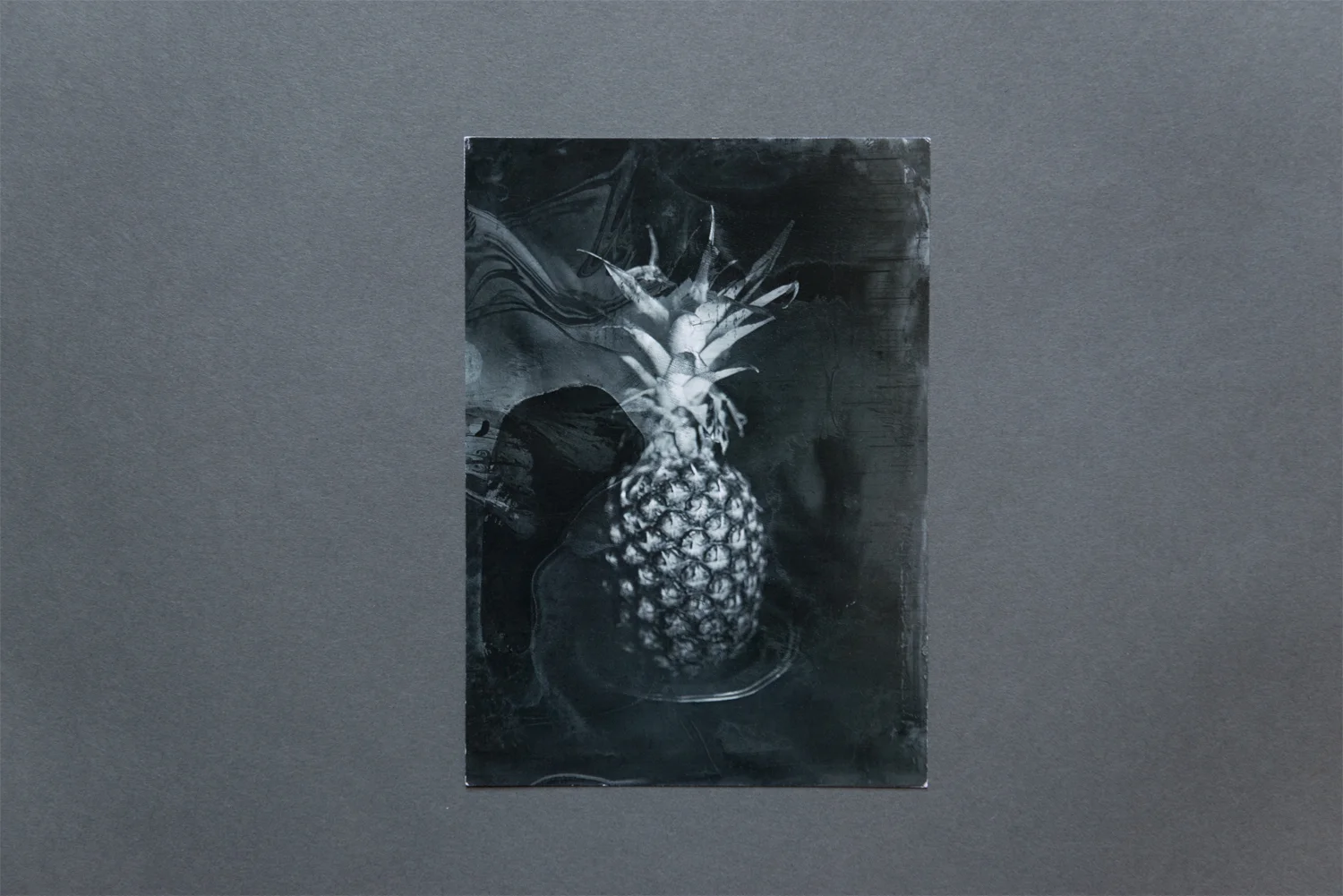 Photographers who work with alternative processes often struggle with reproduction in promotional materials. The complex textures and imperfections of these processes generally require simplicity when it comes to design. Angela Walker’s wet plate collodion series Stilleven is wrought with the artifacts of the chemistry. To keep her promotional postcard uncluttered she fills the front of the card with a single image, saving all text and information for the reverse. Using a grey palate for continuity between the both sides of the card, Walker’s choice of small-serif font with ample spacing the between the letters adds elegance and clean lines to compliment the complicated image. Keeping it simple, Walker uses just her name and website (in san-serif font) along with the title and series of the front image.
