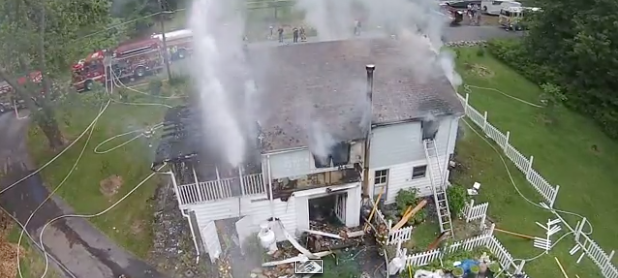 Screenshot of firefighters firing high-pressure hoses at the drone.