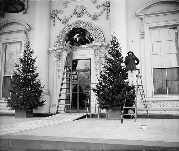 Workmen putting up Christmas decorations on the front of the White House, December 19, 1939. Photo by Harris & Ewing.