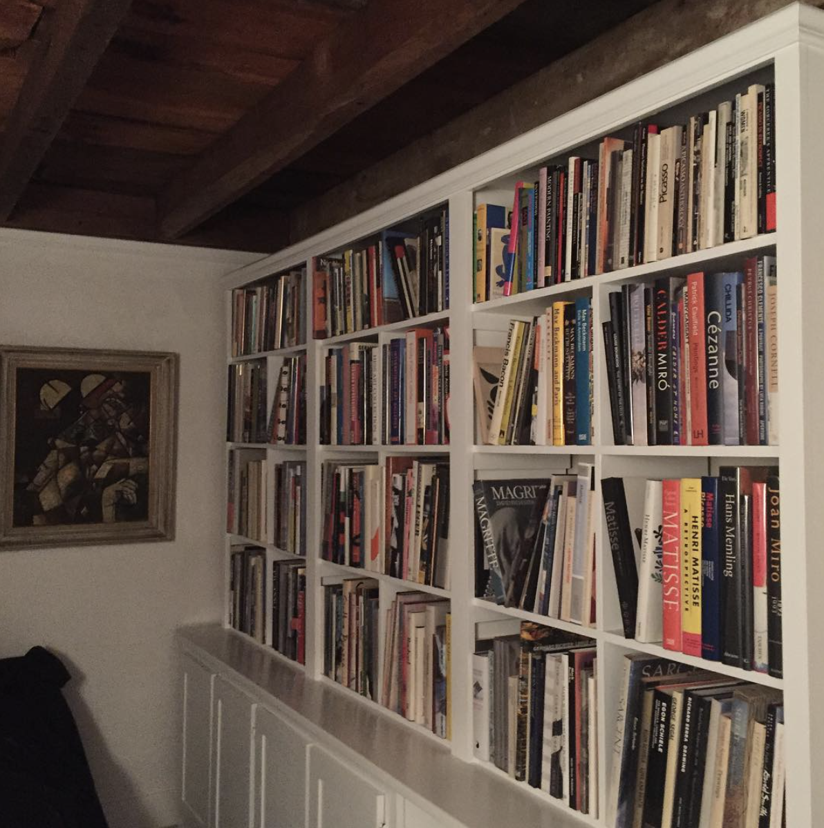 A wall of artist monographs in Marc Leavitt 's collection.