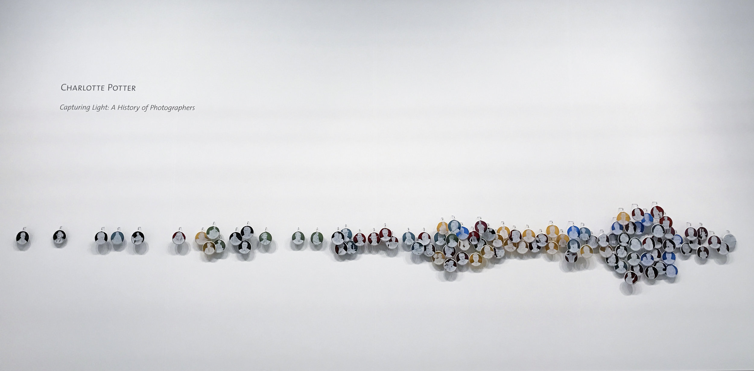 Capturing Light: A History of Photographers , Charlotte Potter, 2017, Hand engraved glass, silver, tin, stainless steel, 3 x 3 inches each cameo, 13 feet long installation. On view at Booth 503.