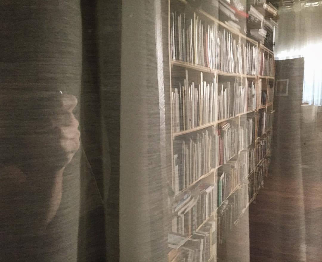 A reflected view of Eliot Dudik 's photobook library.