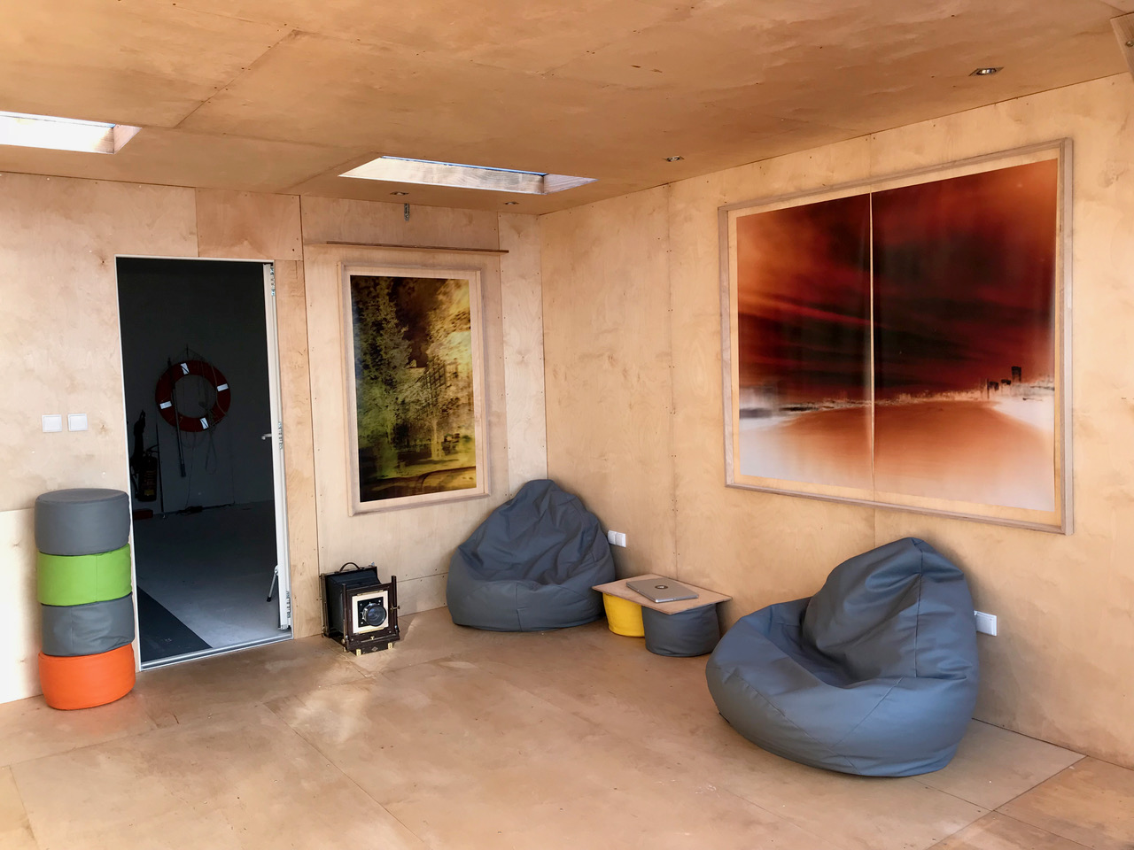 Artist living studio space on the floating camera with photographs from the project hanging on the walls.