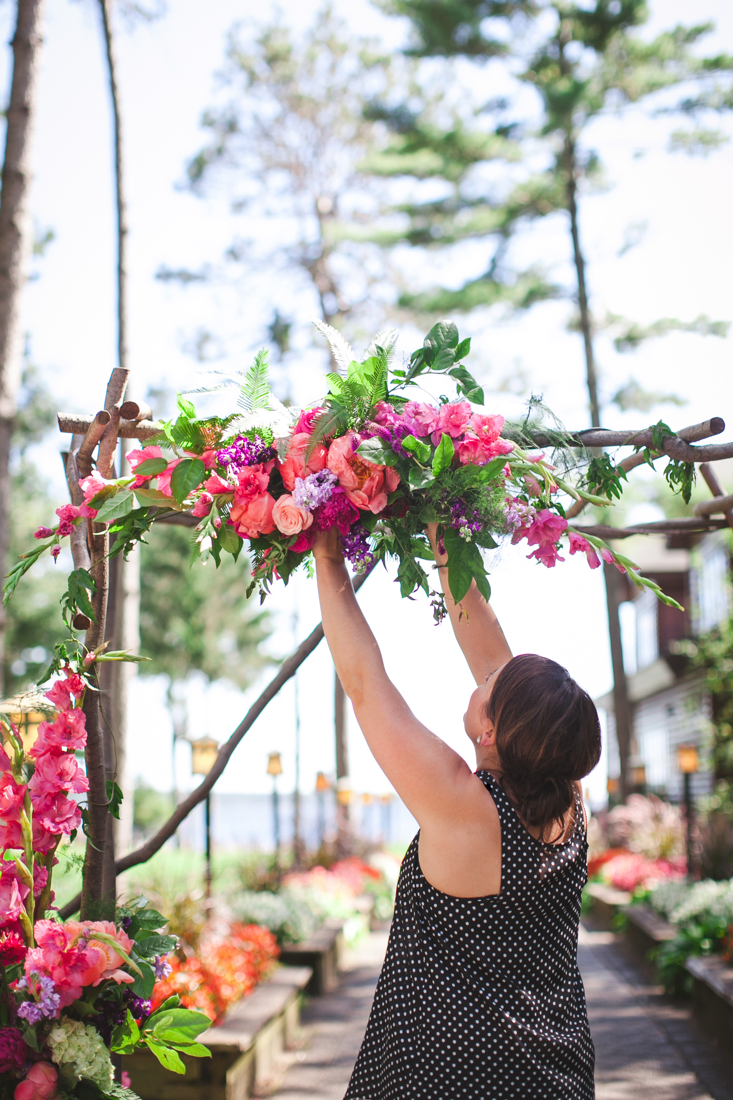 Kate Kuepers of Bloom Designs floralizing a wedding ceremony arbor at Grand View Lodge in Nisswa, Minnesota