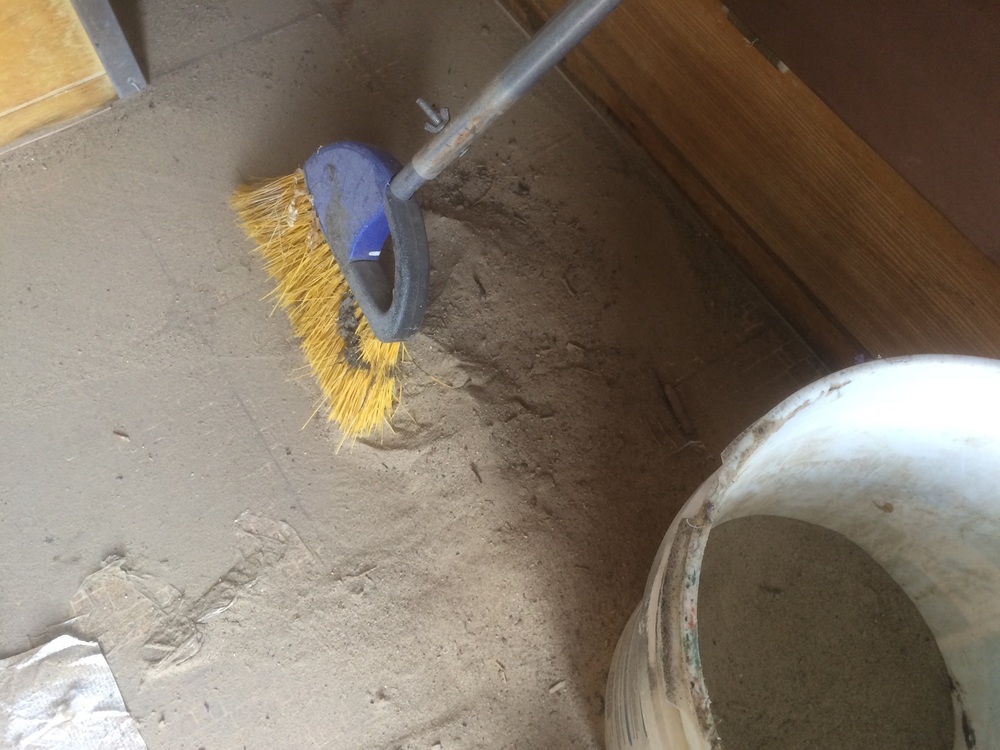 Sweeping sand into the sticky adhesive residue.