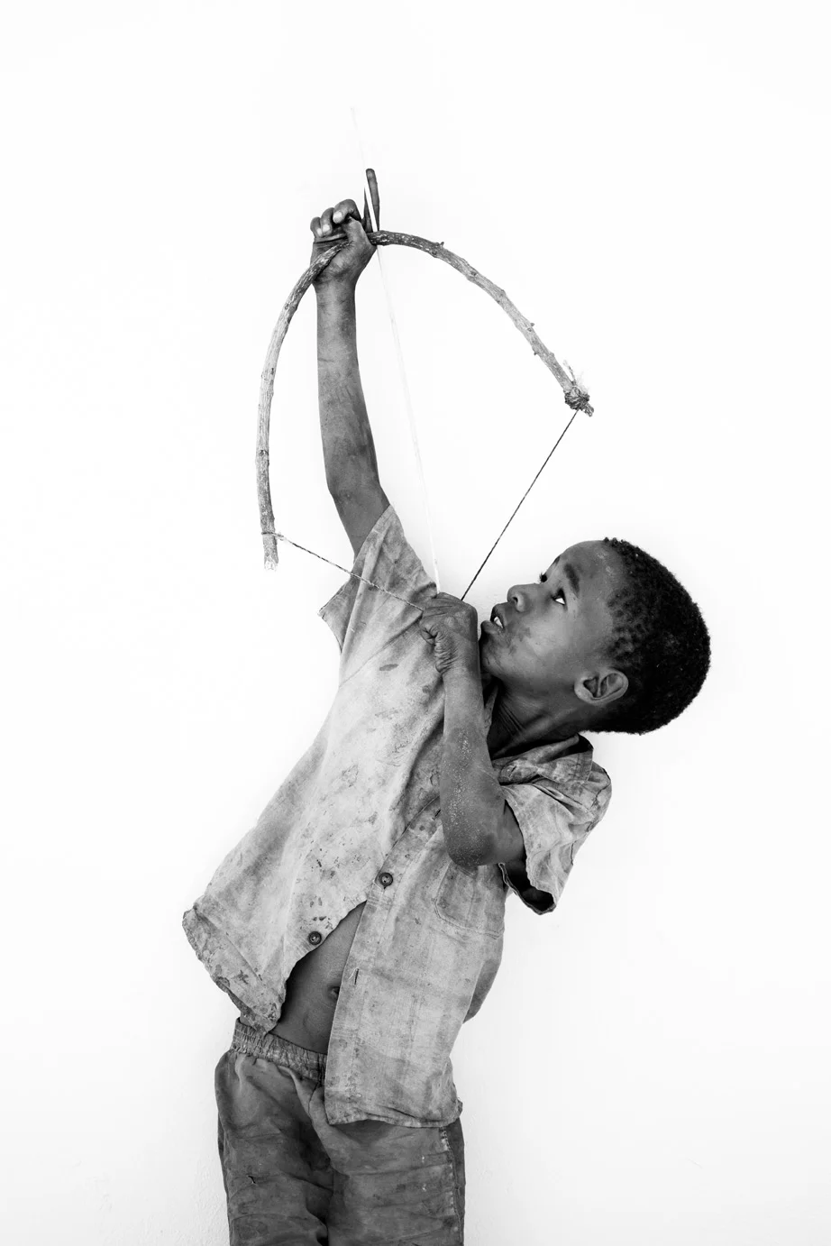 China shoots his handmade bow and arrow up at the sky in Botswana