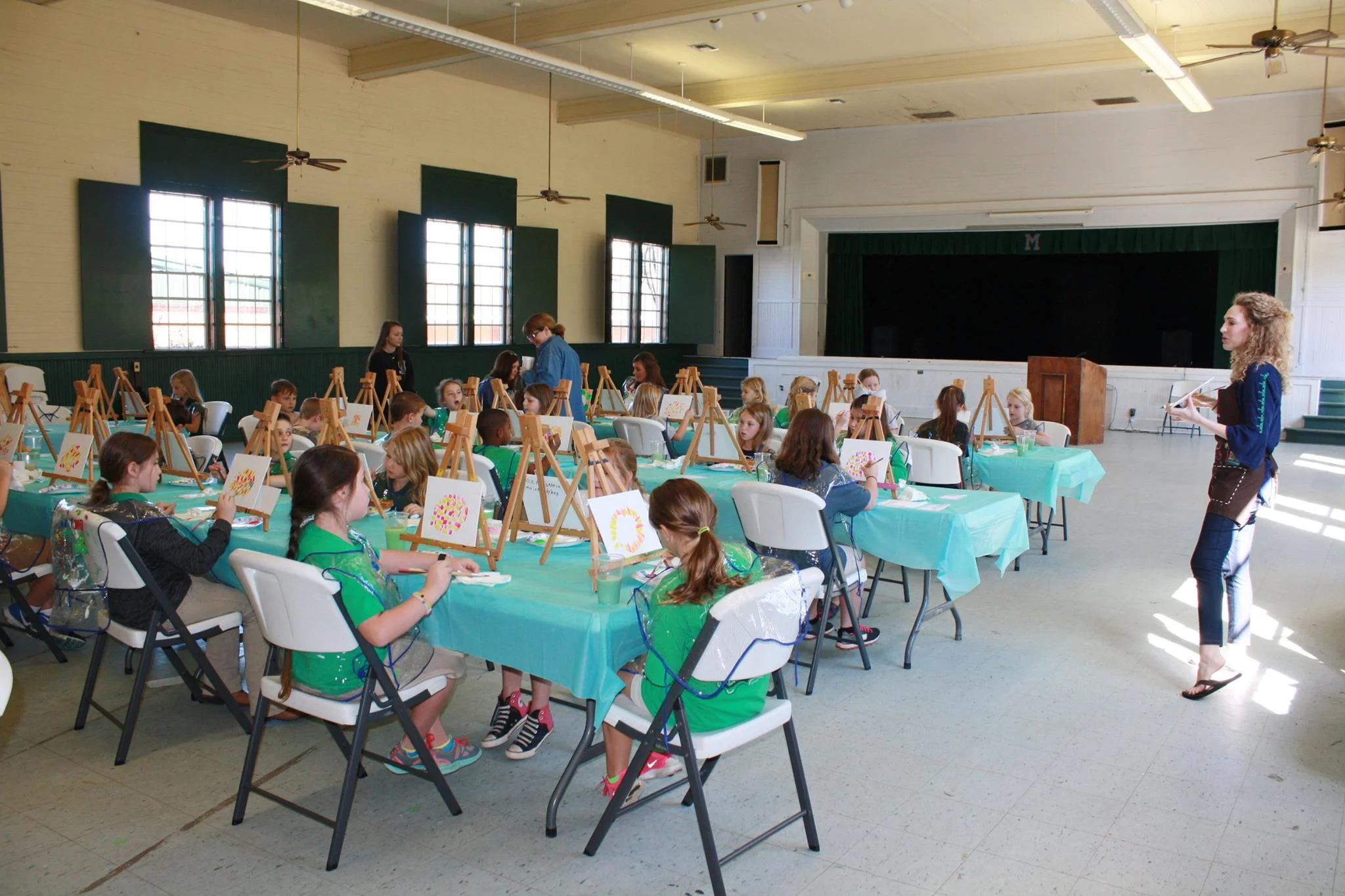 Visiting artist Rianna Turner guides students in painting "Mosaic Turtle" at Millry High School.