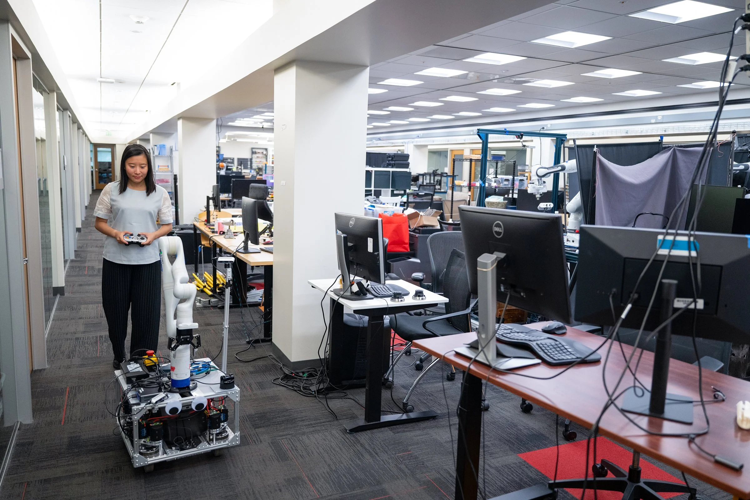 Researcher operating robotic arm in university laboratory, editorial science photography