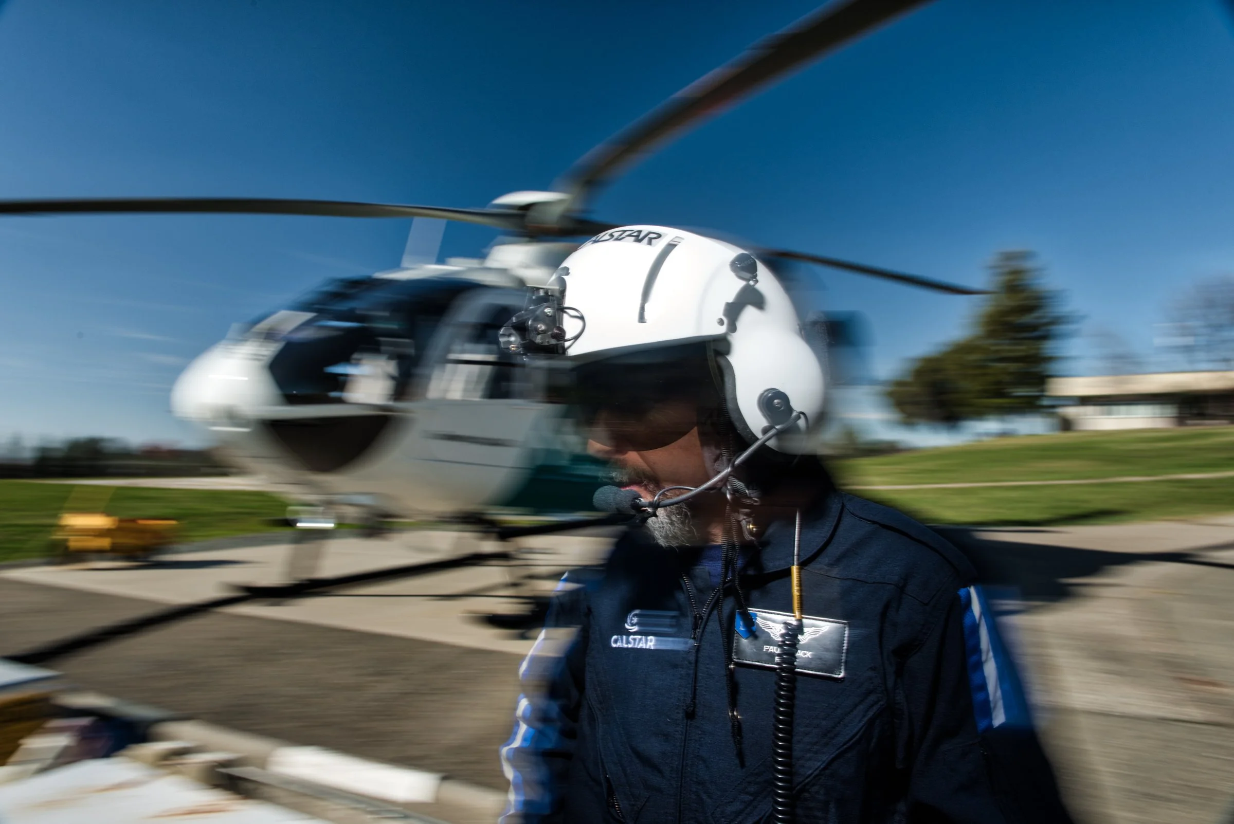 Helicopter pilot with motion blur rotor blades, editorial aviation photography Northern California
