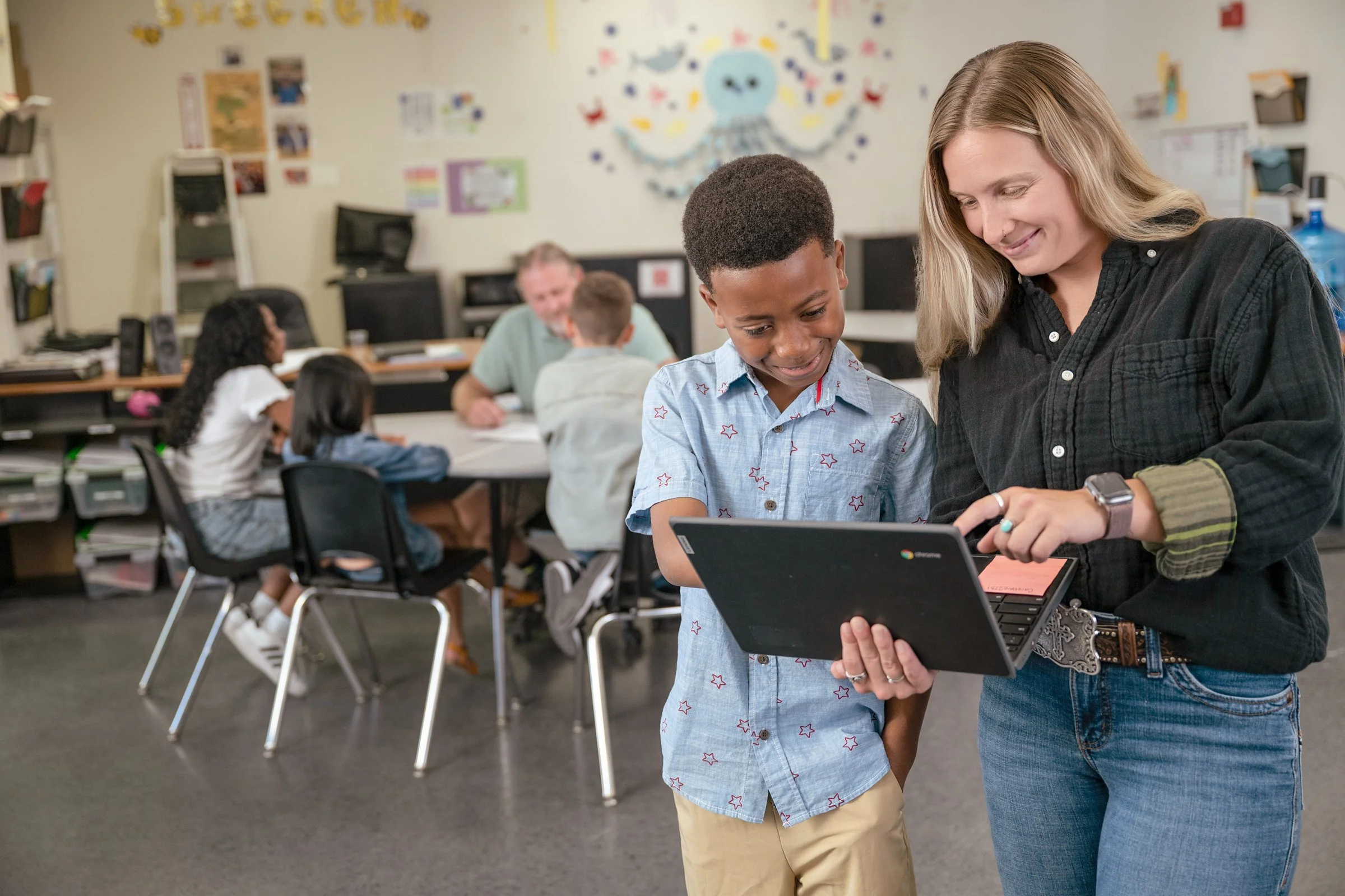 Teacher and student working together on a tablet in a classroom, educational commercial photography Sacramento