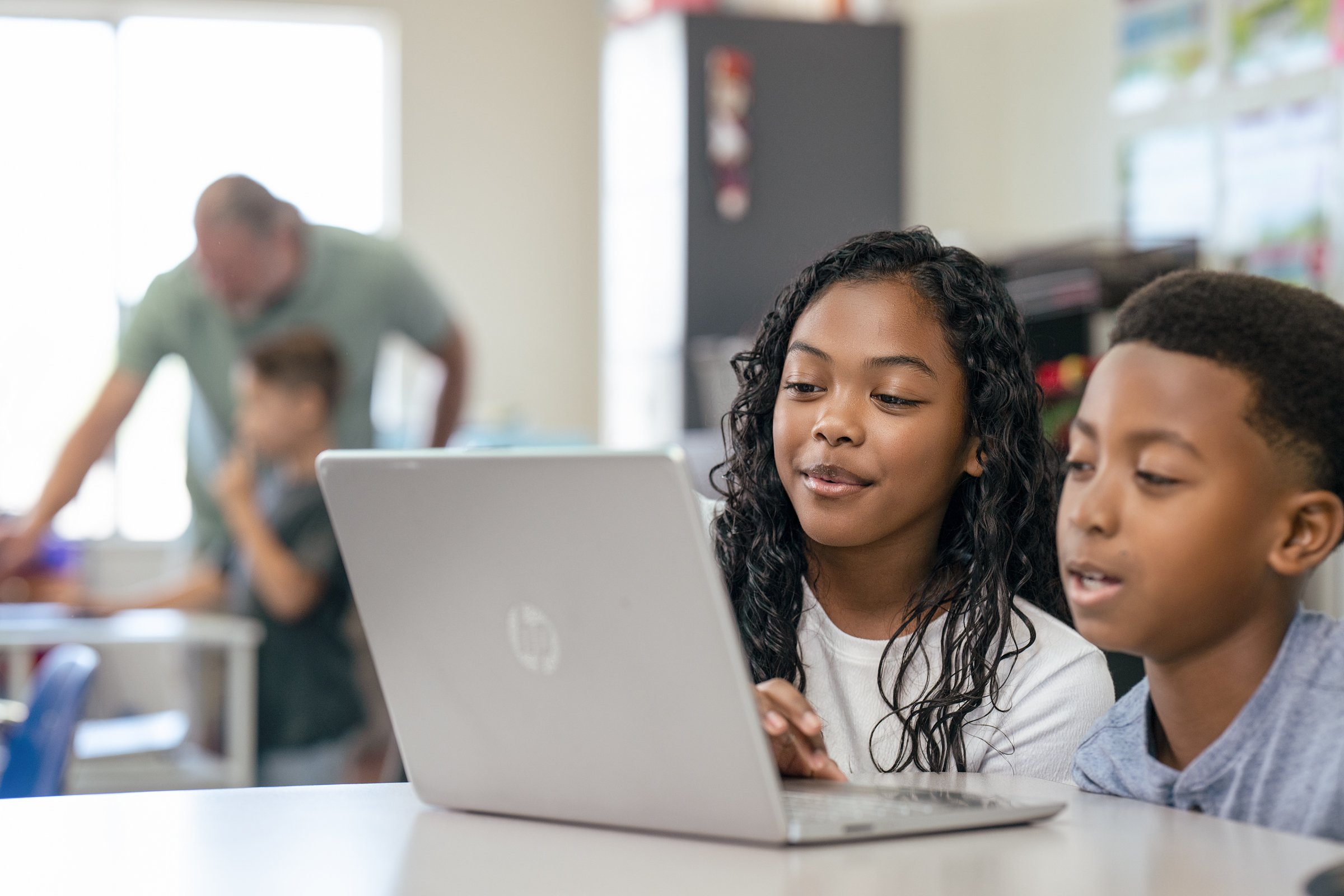 Students working together on a tablet in a classroom setting