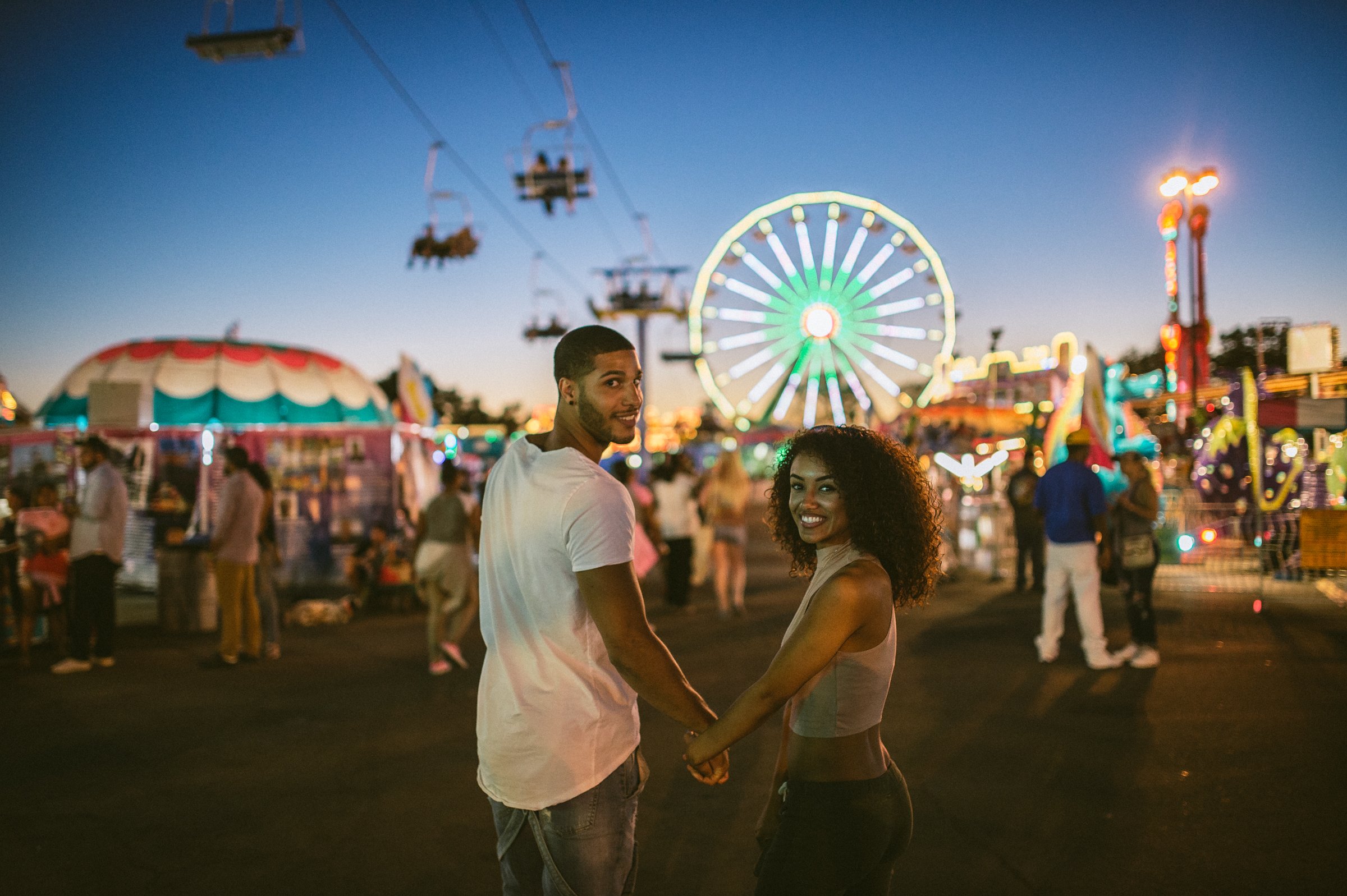 Couple at California State Fair with ferris wheel and carnival lights, editorial lifestyle photography Sacramento
