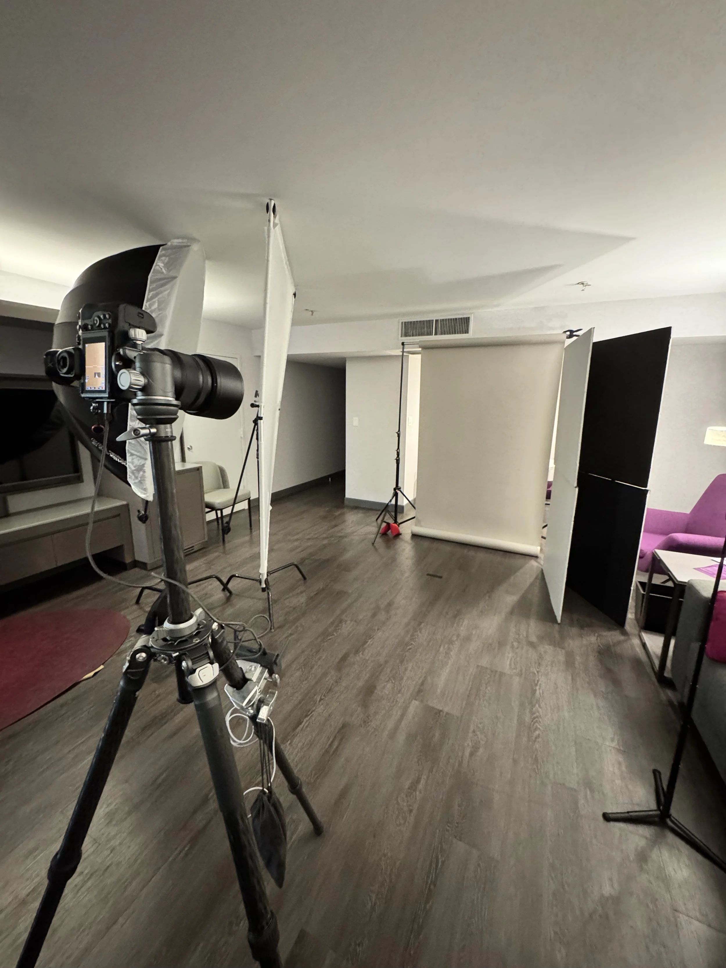 Behind-the-scenes setup for an executive portrait photoshoot, showing camera, lighting equipment, and backdrop in a studio-style environment.