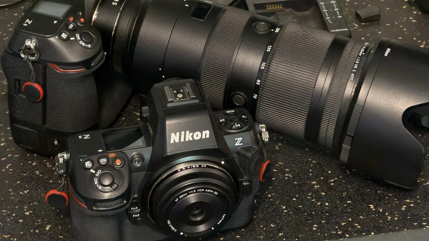 Nikon Z8 with the tiny Viltrox 28mm f/4.5 pancake lens, sitting in front of a Nikon Z9 with a 70-200mm f/2.8 zoom, showing how small the pancake lens is.