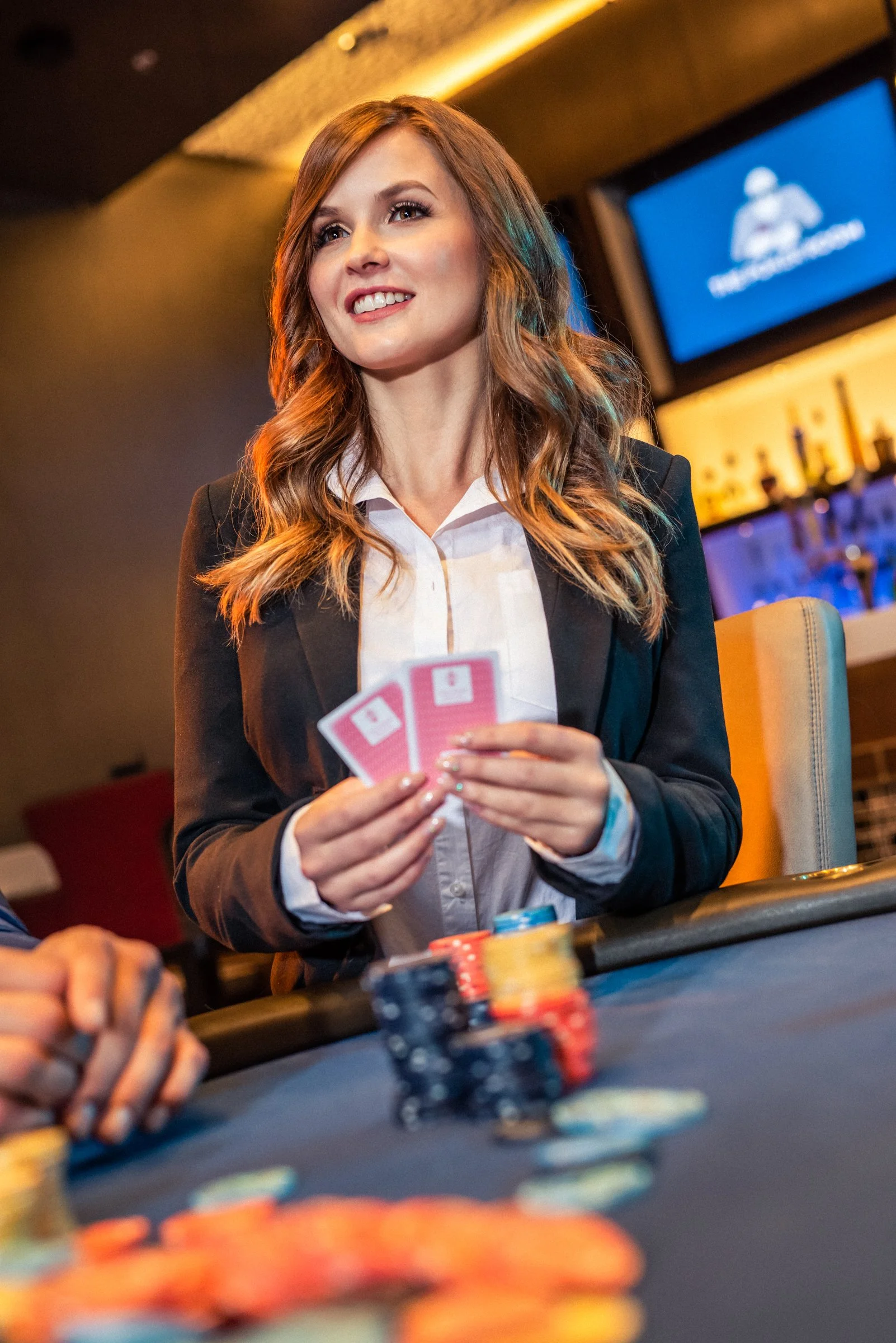 Casino dealer in red dress at gaming table, hospitality commercial photography Sacramento