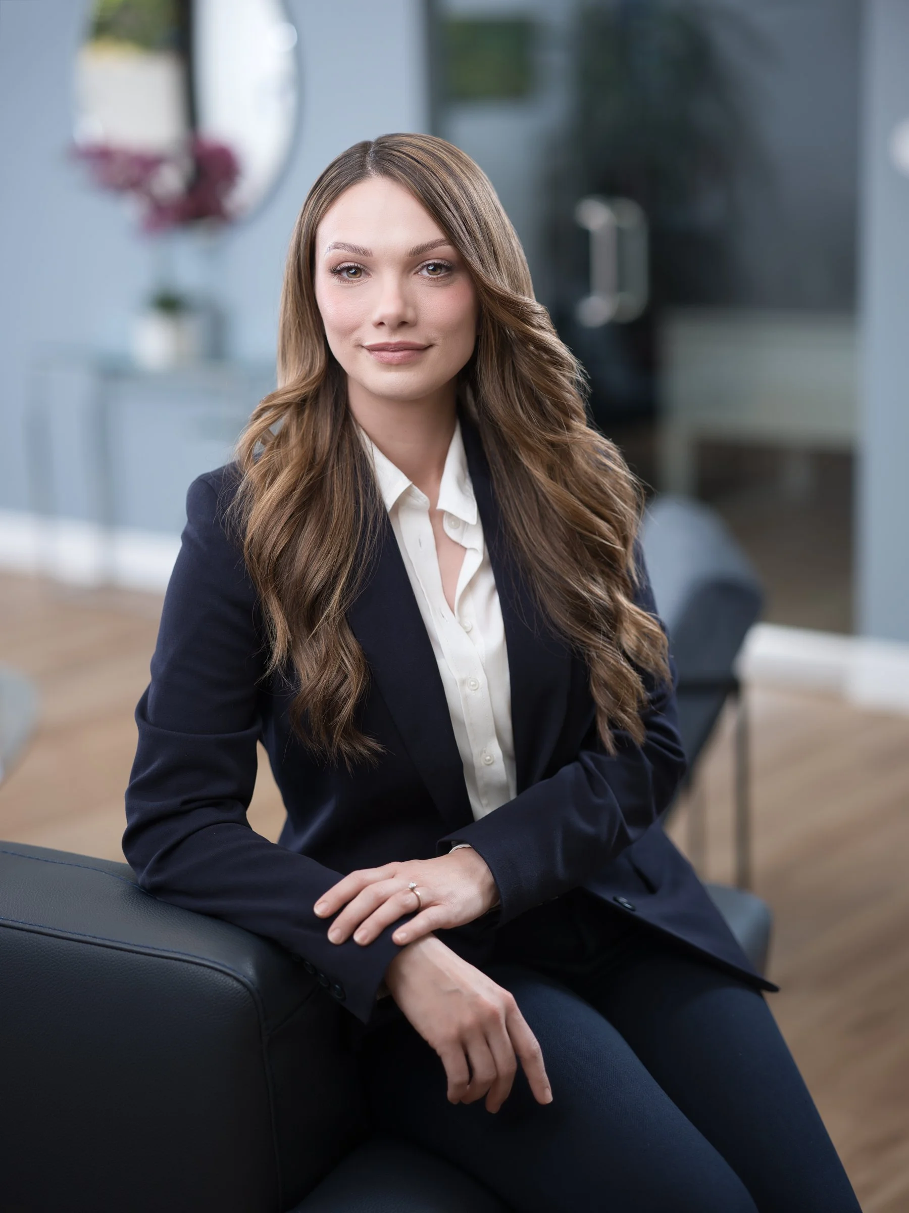 Young female professional in navy suit seated, clean corporate headshot Sacramento