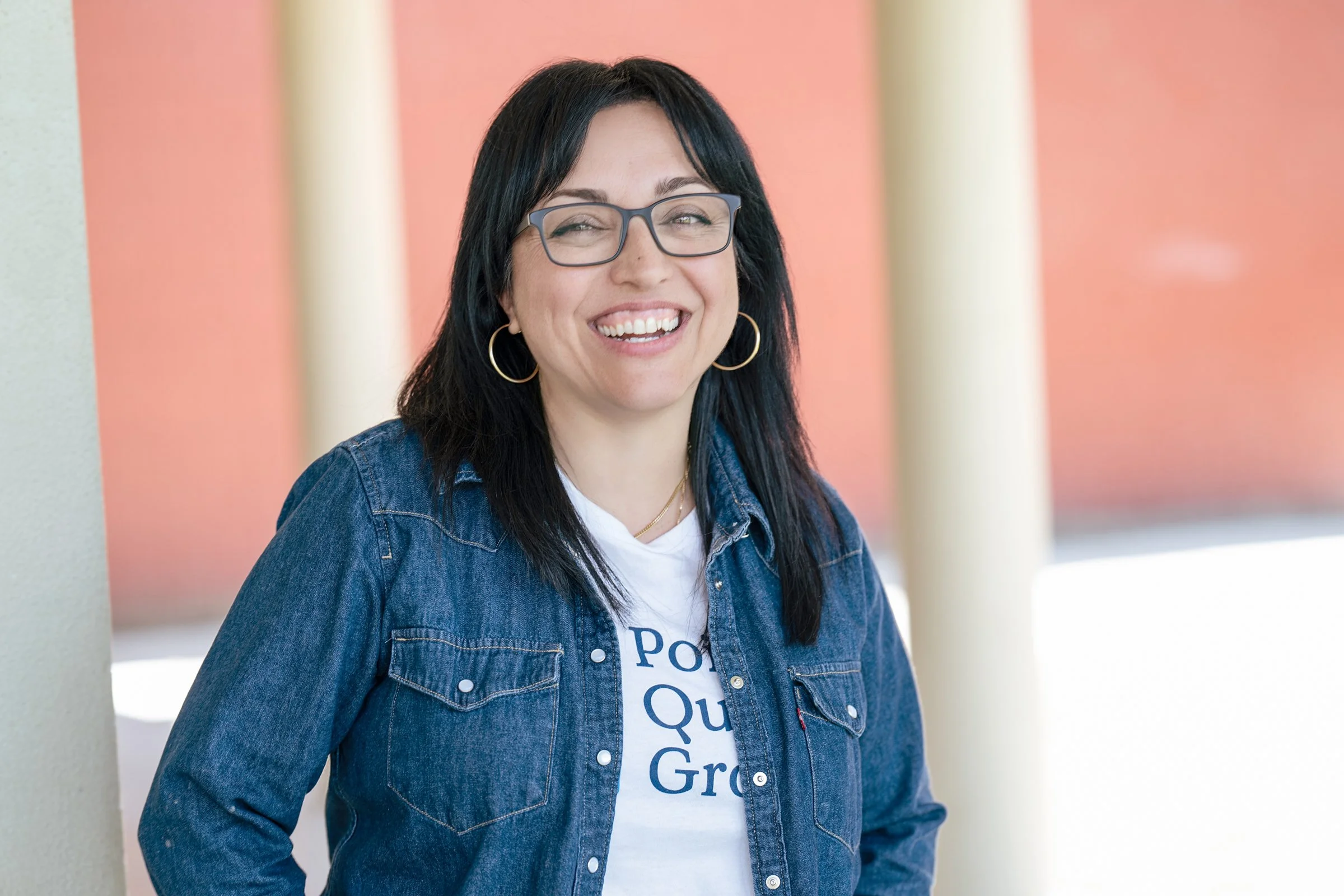 Female professional in denim jacket smiling outdoors, approachable corporate headshot Sacramento