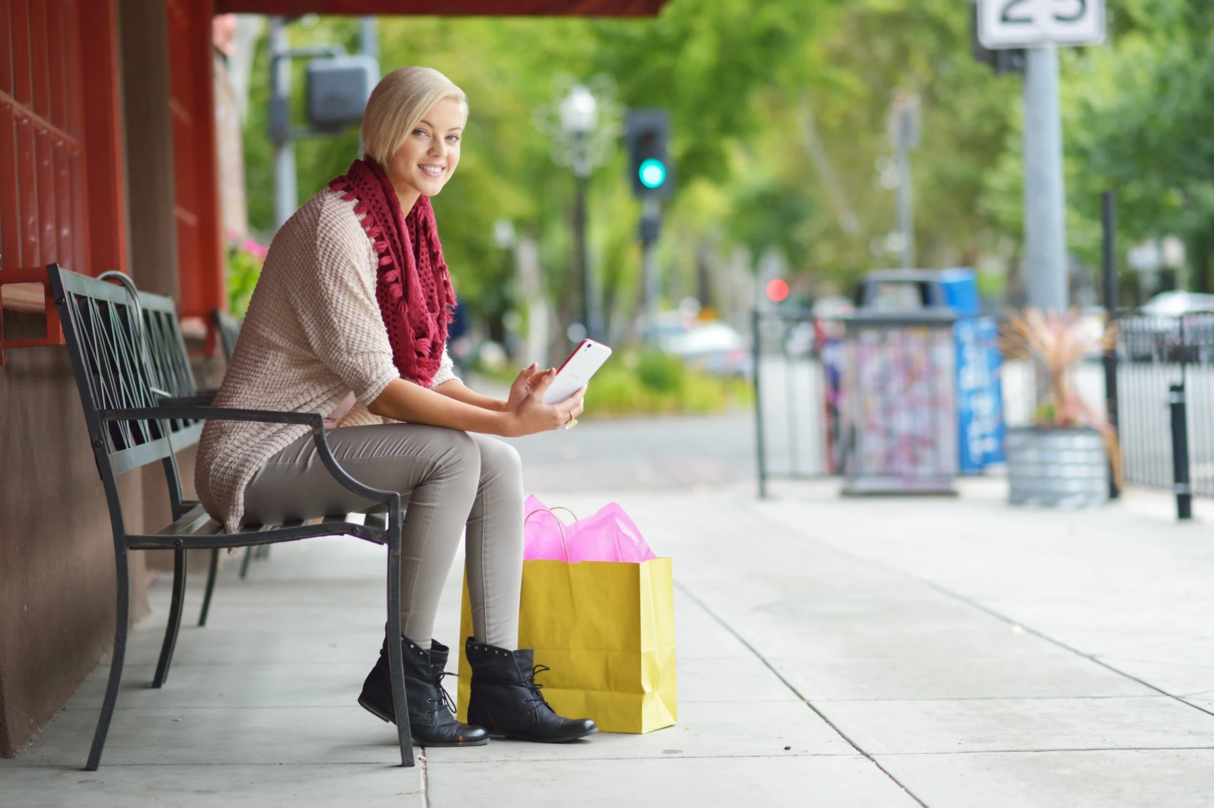 woman sitting on bench in urban setting with shopping bags, lifestyle brand photography Sacramento