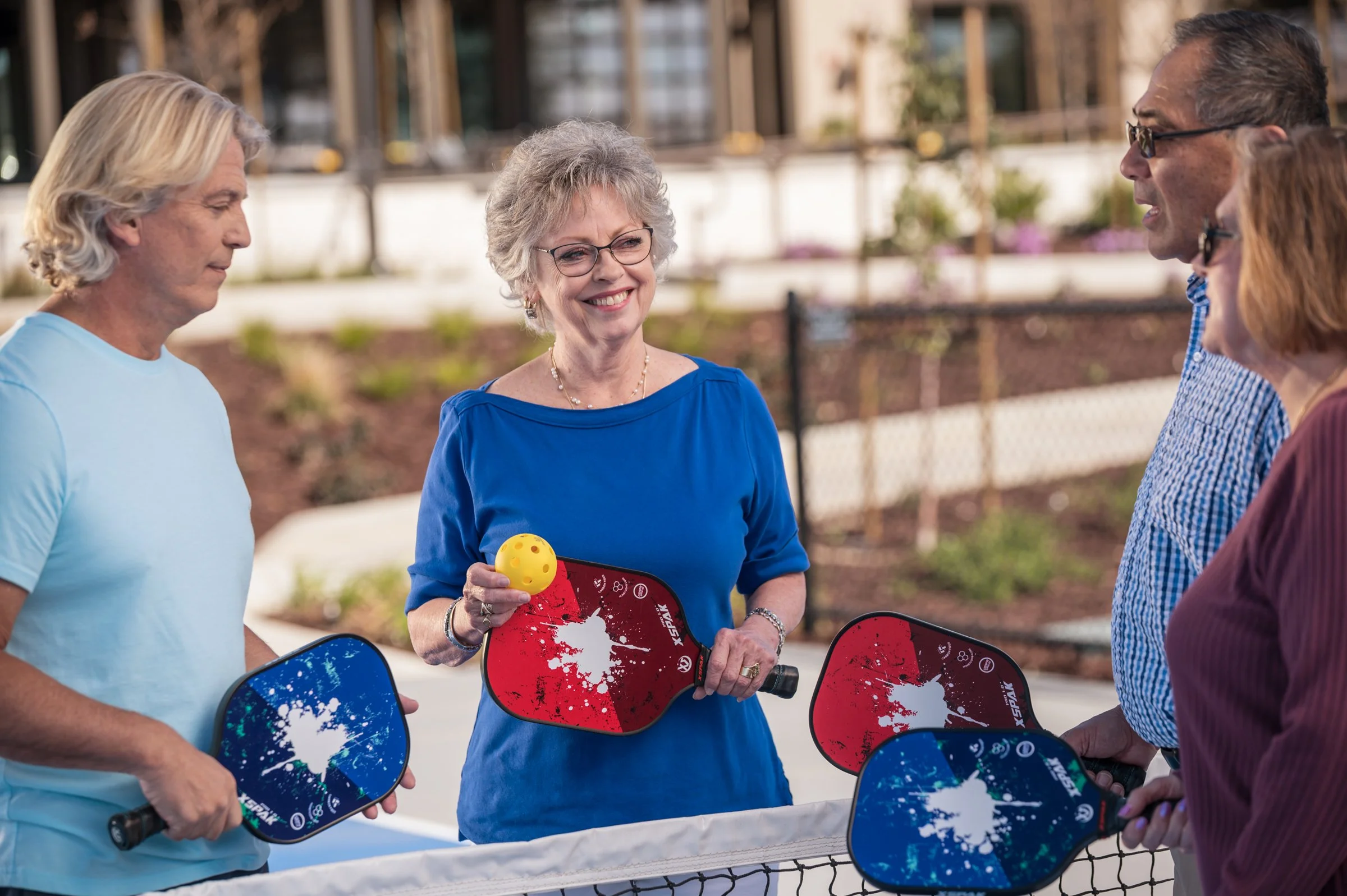 Two older couples playing pickleball outdoors, active lifestyle commercial photography Sacramento