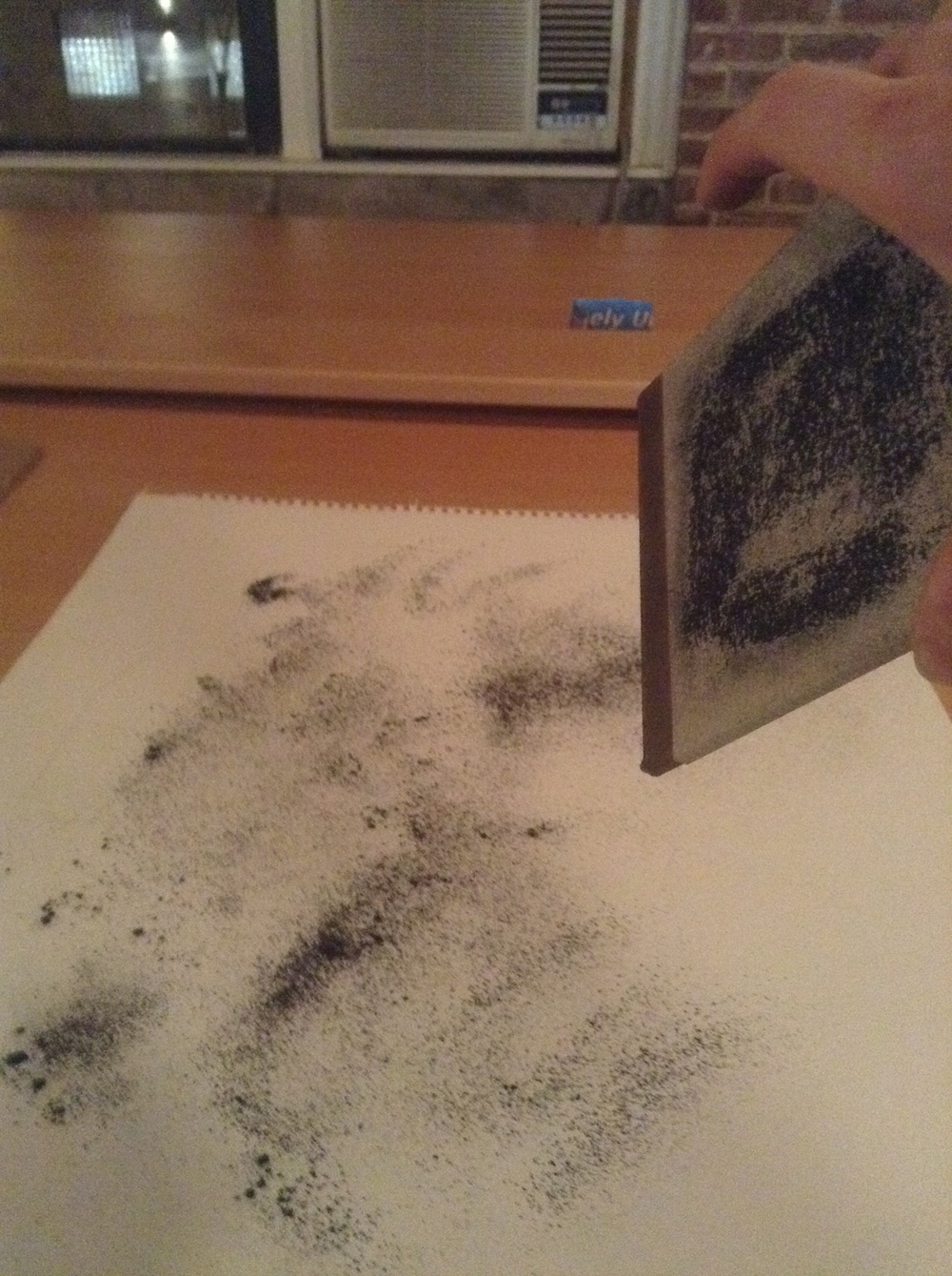  Shaking the graphite powder onto the back of the drawing. 