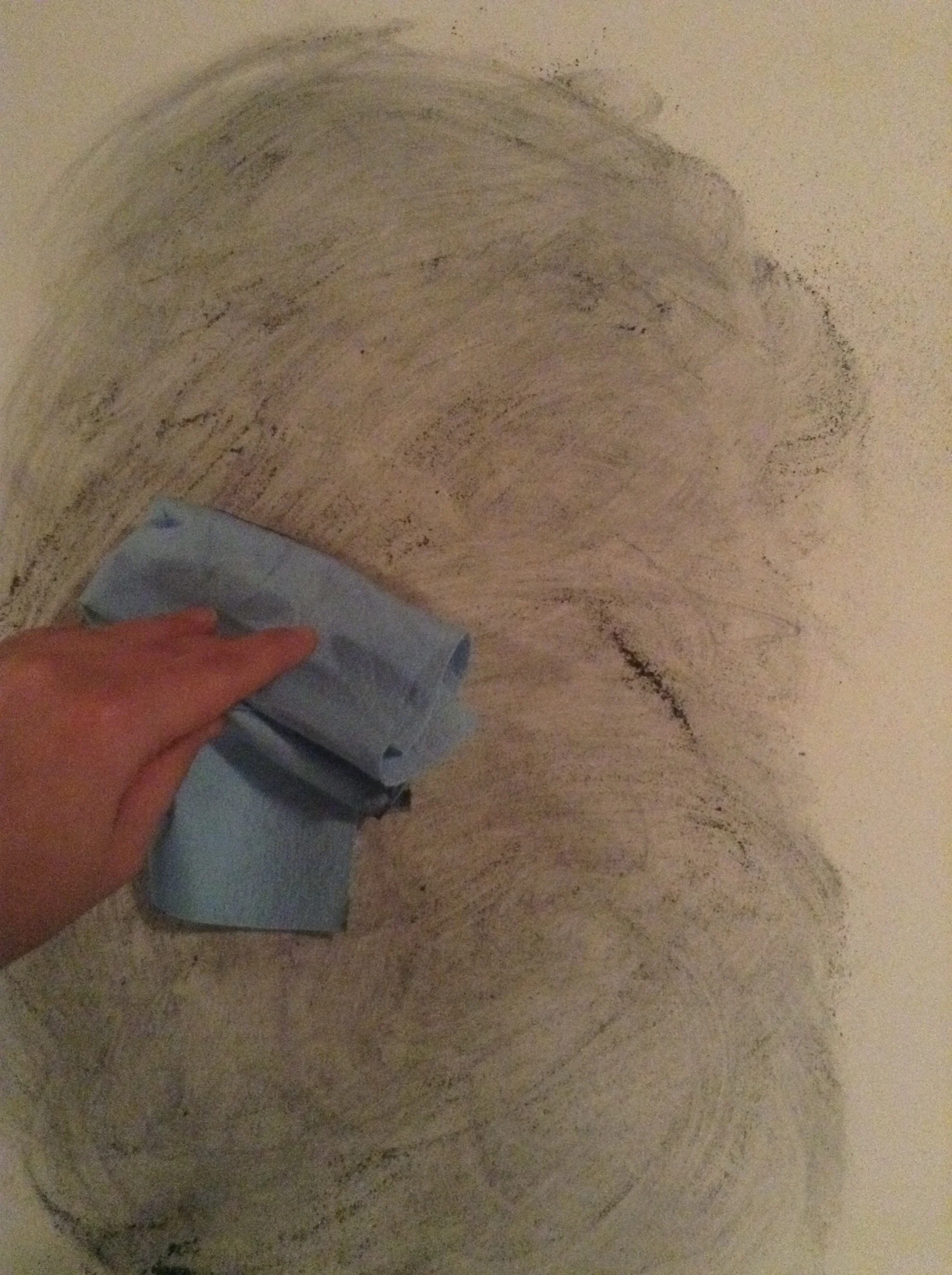 Smearing it around with a paper towel. 