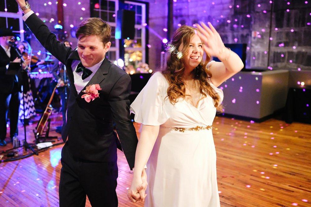 myself and my wife dancing at our wedding! There is a band playing in the background, and purple lights reflecting of a disco ball all around us