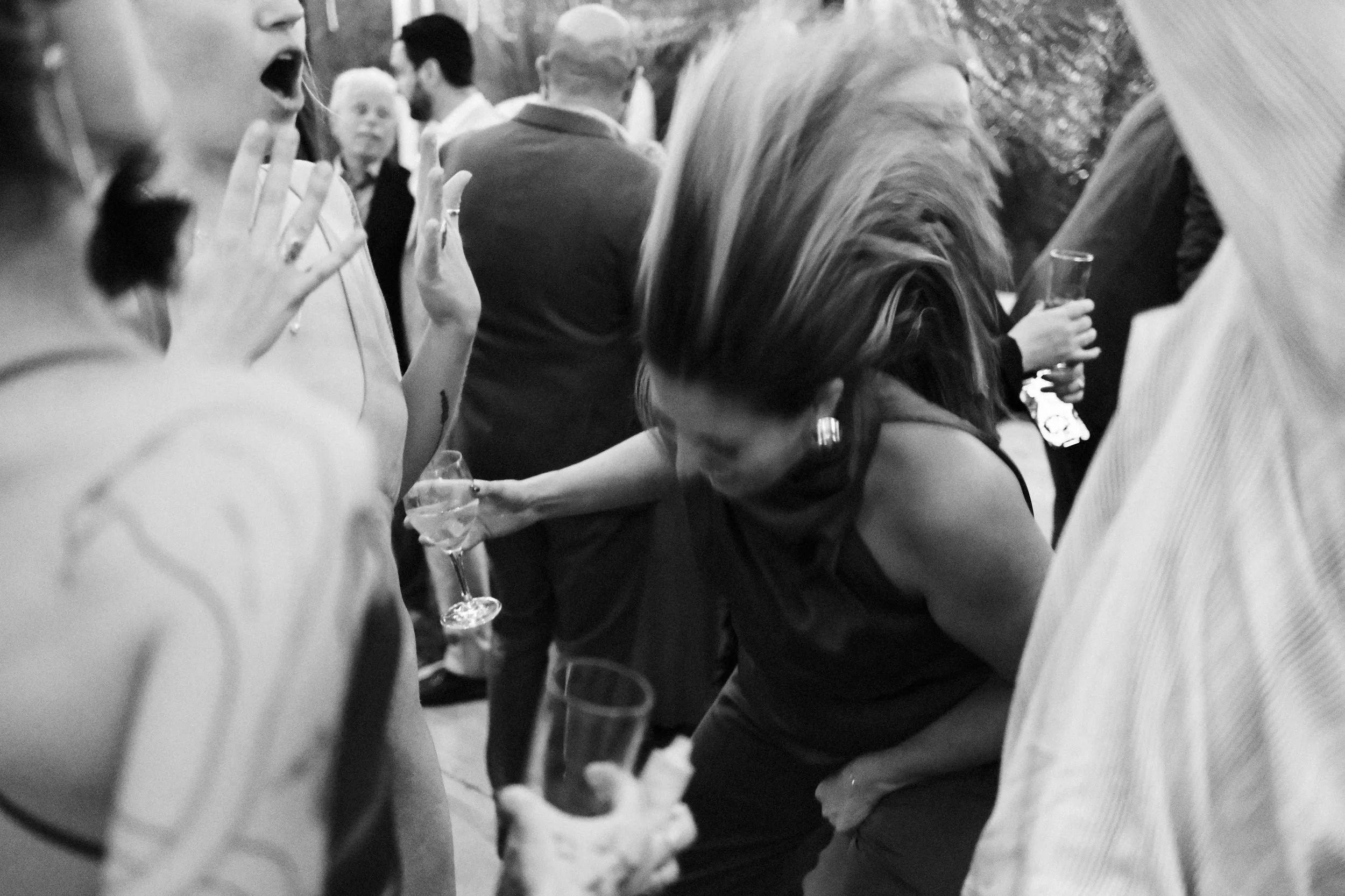 People at a social gathering holding drinks, engaging in conversation, and appearing to enjoy the event.