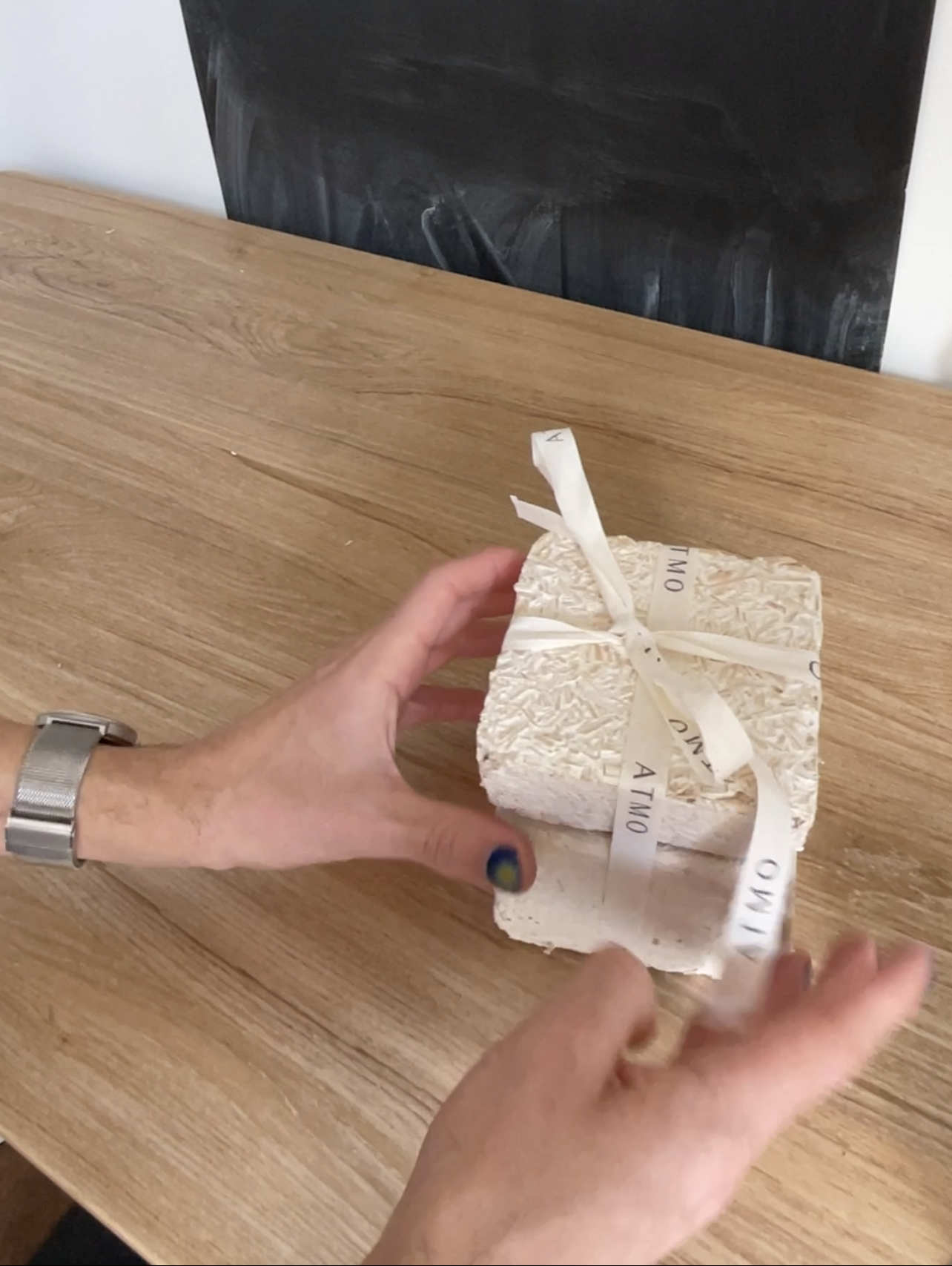 Hand holding Atmo candle packaged.PNG