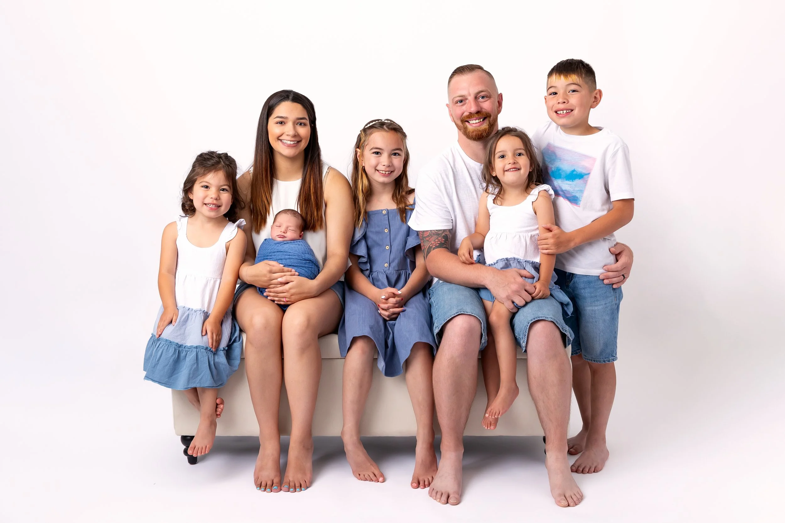 Family photo with newborn, parents and siblings in studio
