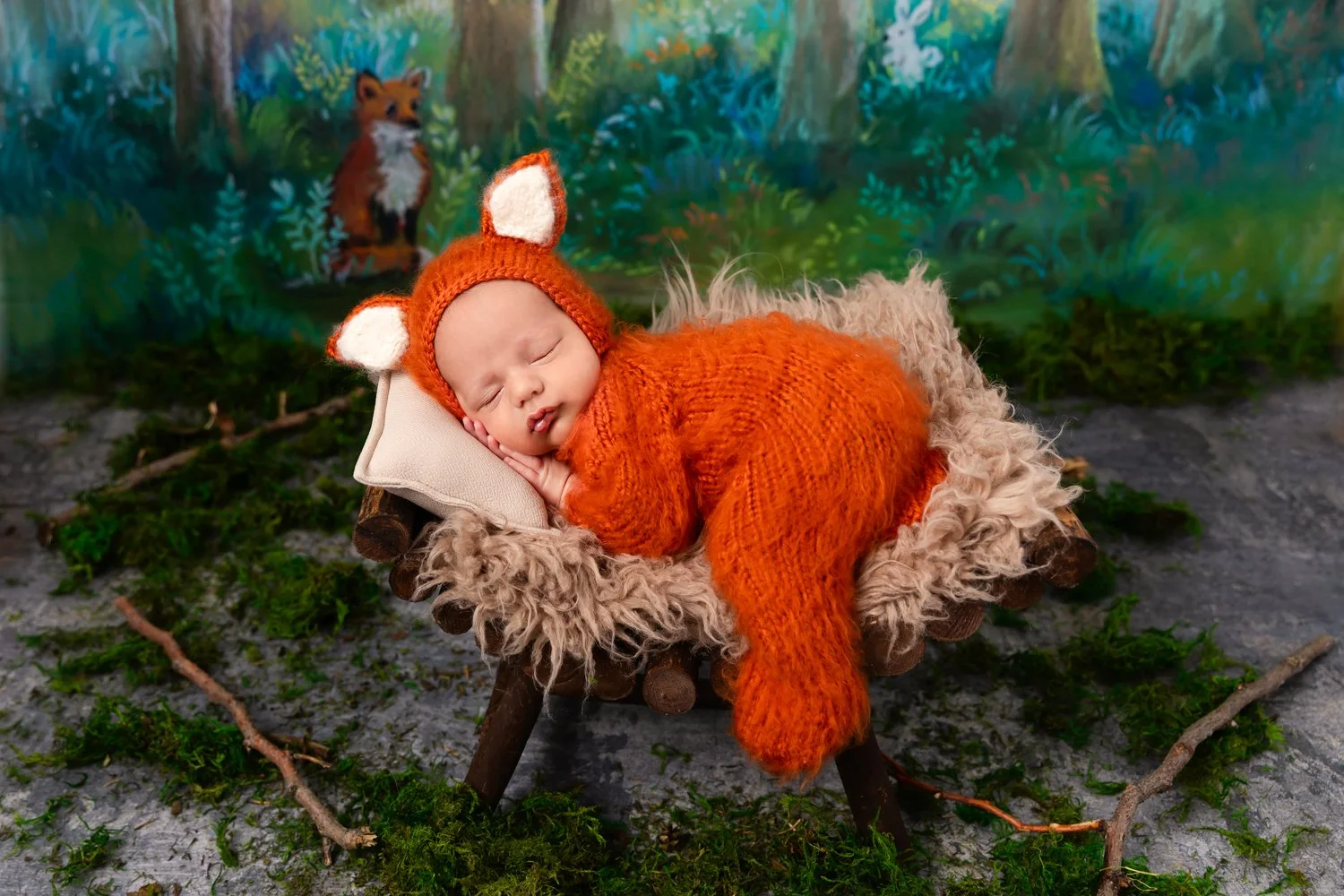 A baby dressed as a fox, sleeping on a small wooden bed with a cozy fur blanket and a knitted fox costume hat, in front of a colorful forest backdrop.