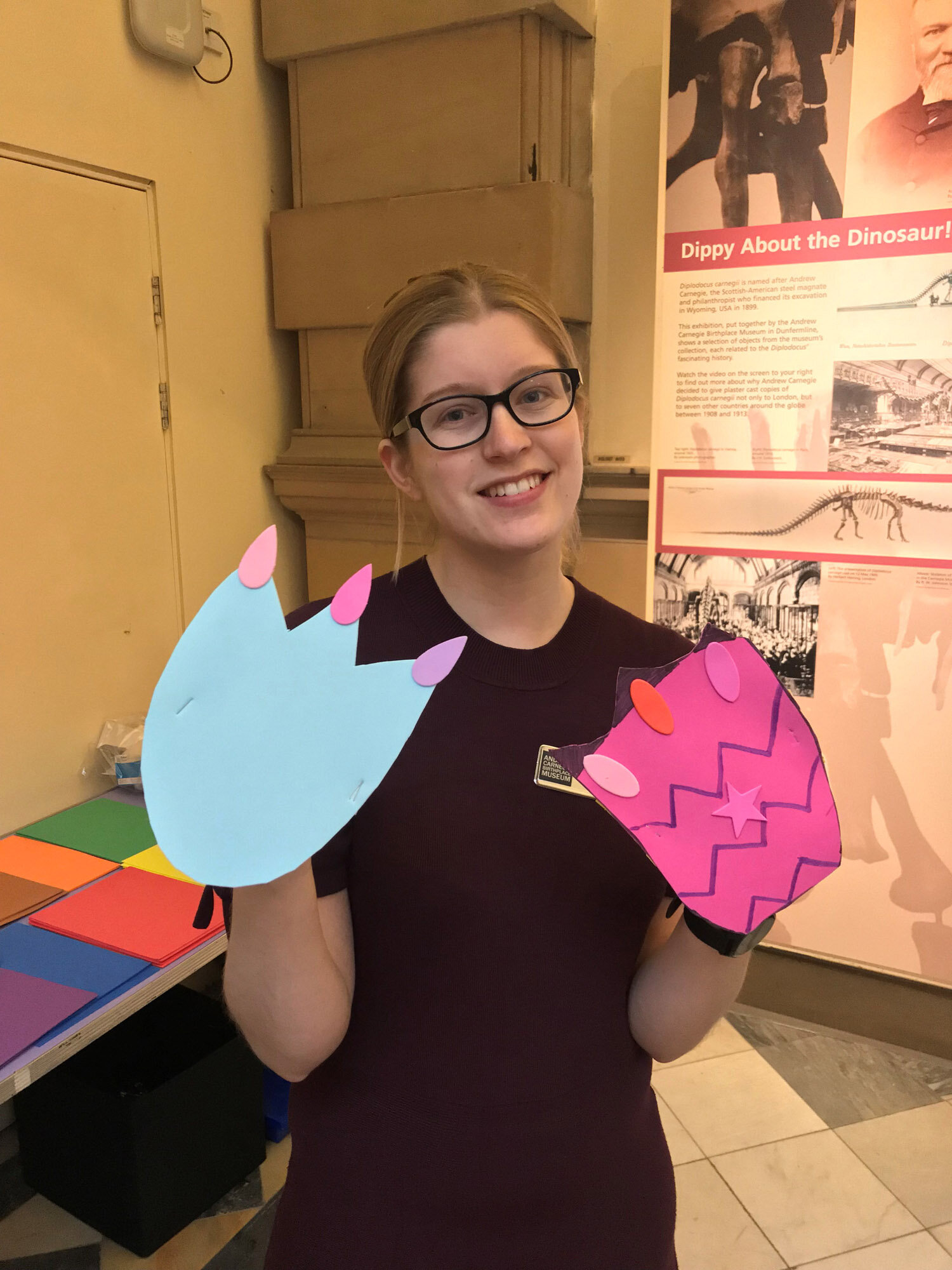  The Andrew Carnegie Birthplace Museum’s Learning Officer is showing a dino-hands craft.  