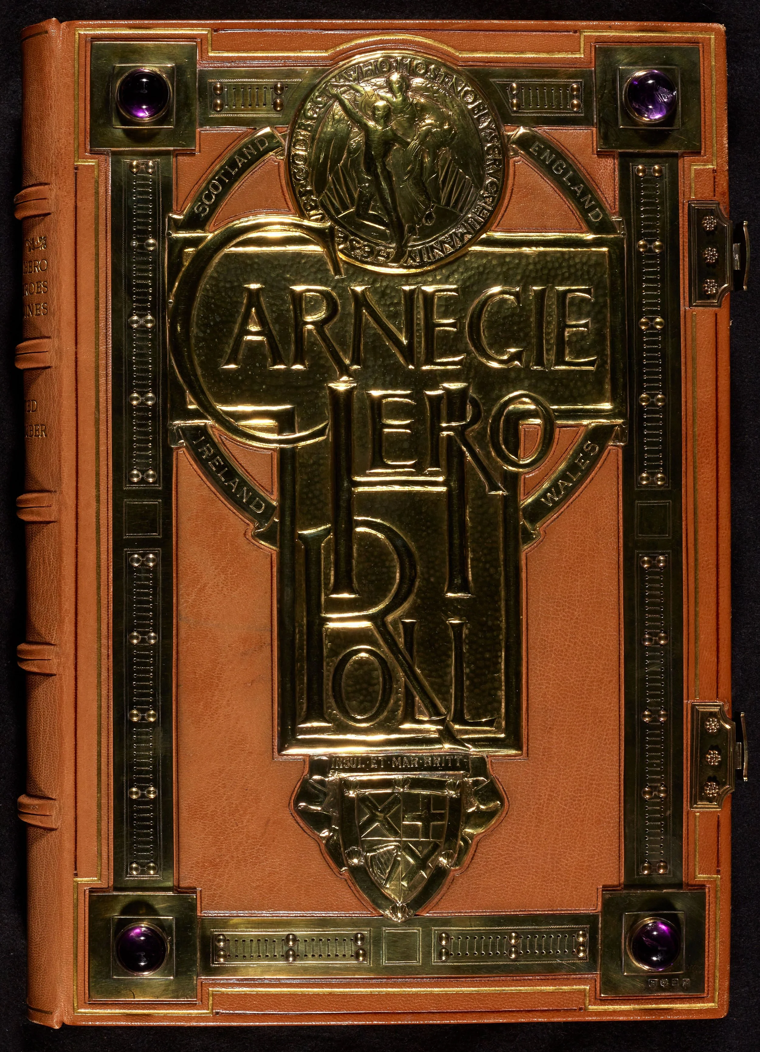 Image of the first volume of the Carnegie Hero Roll. The book is bound in a brown leather, decorated with ornate metal and includes amethyst corner decorations.