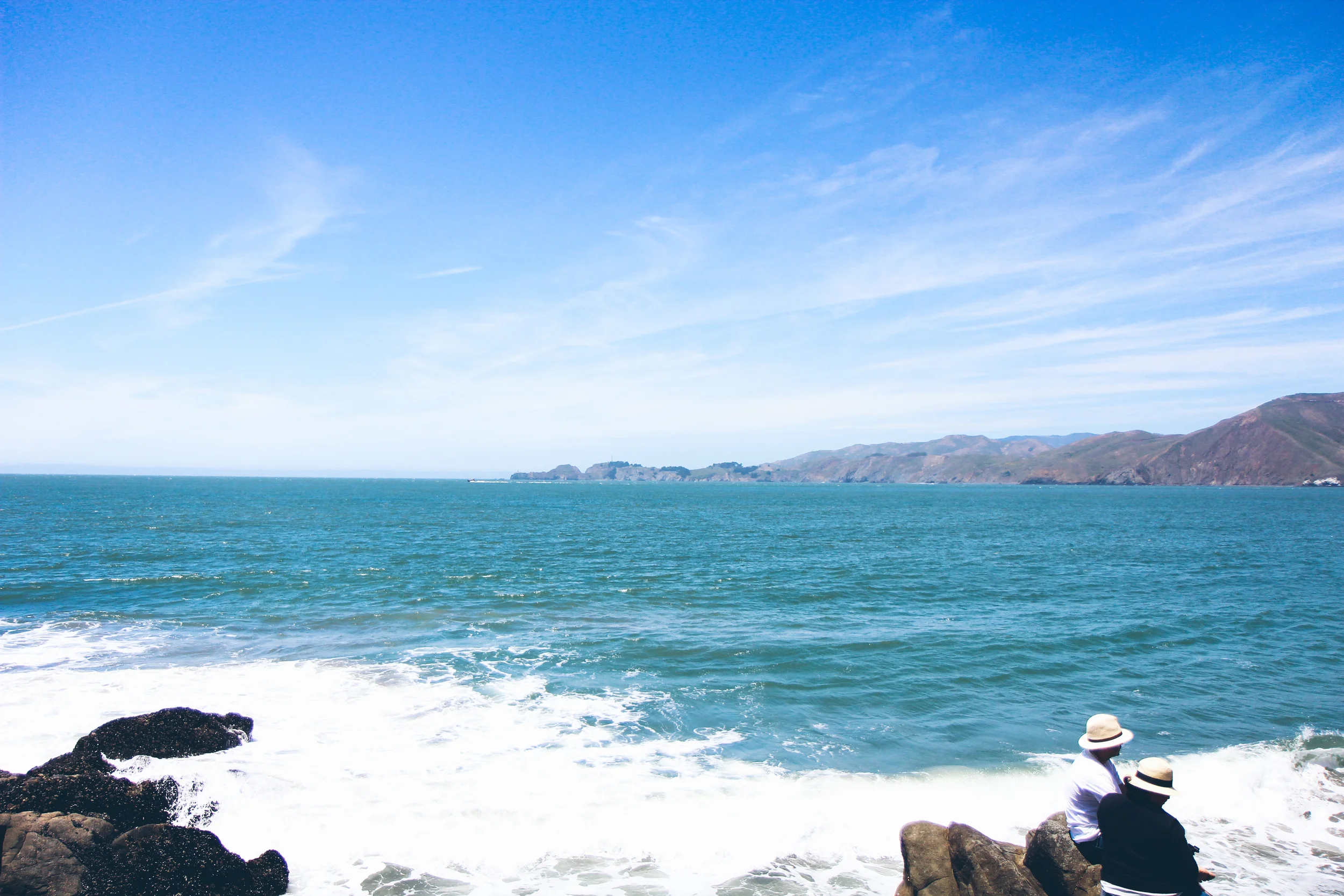 Cute couple in fedoras on the beach.