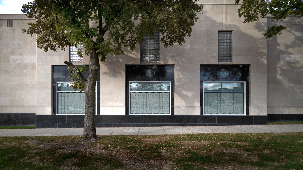 with/without Maureen Nollette Covering the windows at Site:LAB with transparent and semi transparent materials creates a situation where a viewer must look at the windows and not through them. This intended redirection of expectations is created by using ordinary materials for unusual purposes. Hand cut contact paper (shelving paper) is patterned after a graphic element found on the facade of the building, referencing it without directly copying it. It is then repeated across all of the windows, lit and backed by scrim; the pattern disappears at times, casts shadows, and sets up anticipation for the interior. My work has been shown internationally and throughout the Midwest and East Coast, and is held in public collections including Detroit Institute of Art Museum, Yves St. Laurent, MGM Mirage Hotel, the Birch Pond Group (j.jill Retail Stores) in addition to private collections. I am a recipient of awards and honors including Honorable Mention in the 25th International Juried Art Show in NJ, alternate for the Maria Walsh Sharpe Foundation Studio Award in NY, the Graduate Award from the City University of New York, and Honorable Mention in the 12th Annual National Small Works Exhibition in NY. I was Guest Lecturer at Calvin College, Grand Rapids Art Museum and School of Visual Arts and taught for four years at Kendall College of Art and Design. I hold a MFA from The City University of New York, Queens; a BFA from Kansas City Art Institute, and a BA from University of Nebraska. My work adopts repetition, pattern and the grid to communicate information that references the passage of time. Sensual, subtle, non-representational and systematic, the work is composed of a dense accumulation of ordinary materials positioned through labor-intensive processes that allow the materials to transcend their perceived function. This process of making is slow, deliberate, and connects my thoughts to the physical world; and through my process, the everyday, the in-between, the time spent waiting is implicit and results in a form. I often use the grid as a connecter for my materials. The order of a grid allows the imperfections of my actions to be noticed and deify the implied perfection and logic of the underlying structure. The historical signi!cance of the grid in quilting and in high modernism (craft and art) is also of great interest to me. Both employ the grid as a vehicle yet are valued unequally by contemporary society. Craft is regulated to a utilitarian function or women’s work, while art is given a higher value.