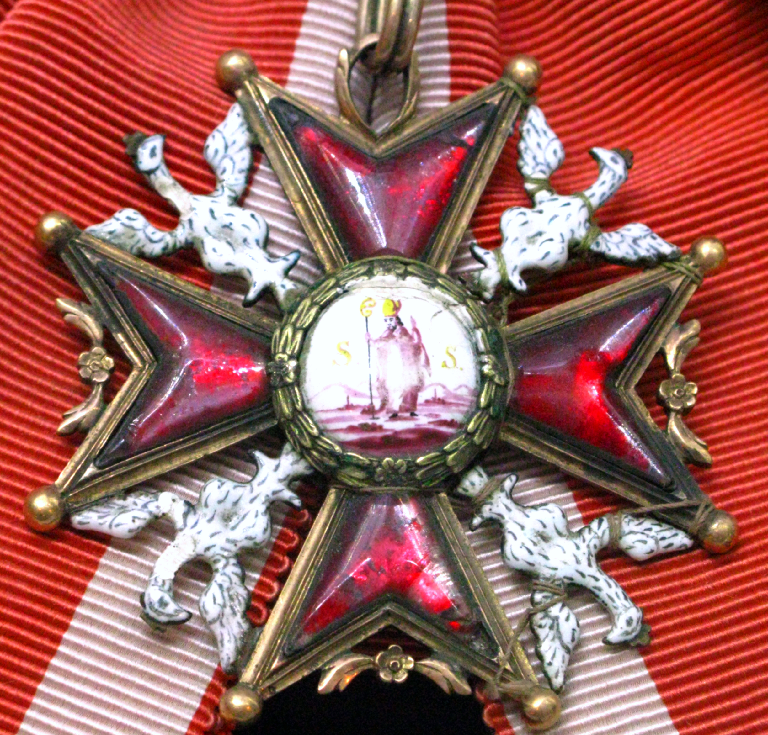A late 18th century badge of the Polish Royal Order of St. Stanislas with the image of the saint, original Polish white eagles in the axillae, and ruby glass set in the arms of the Maltese cross.